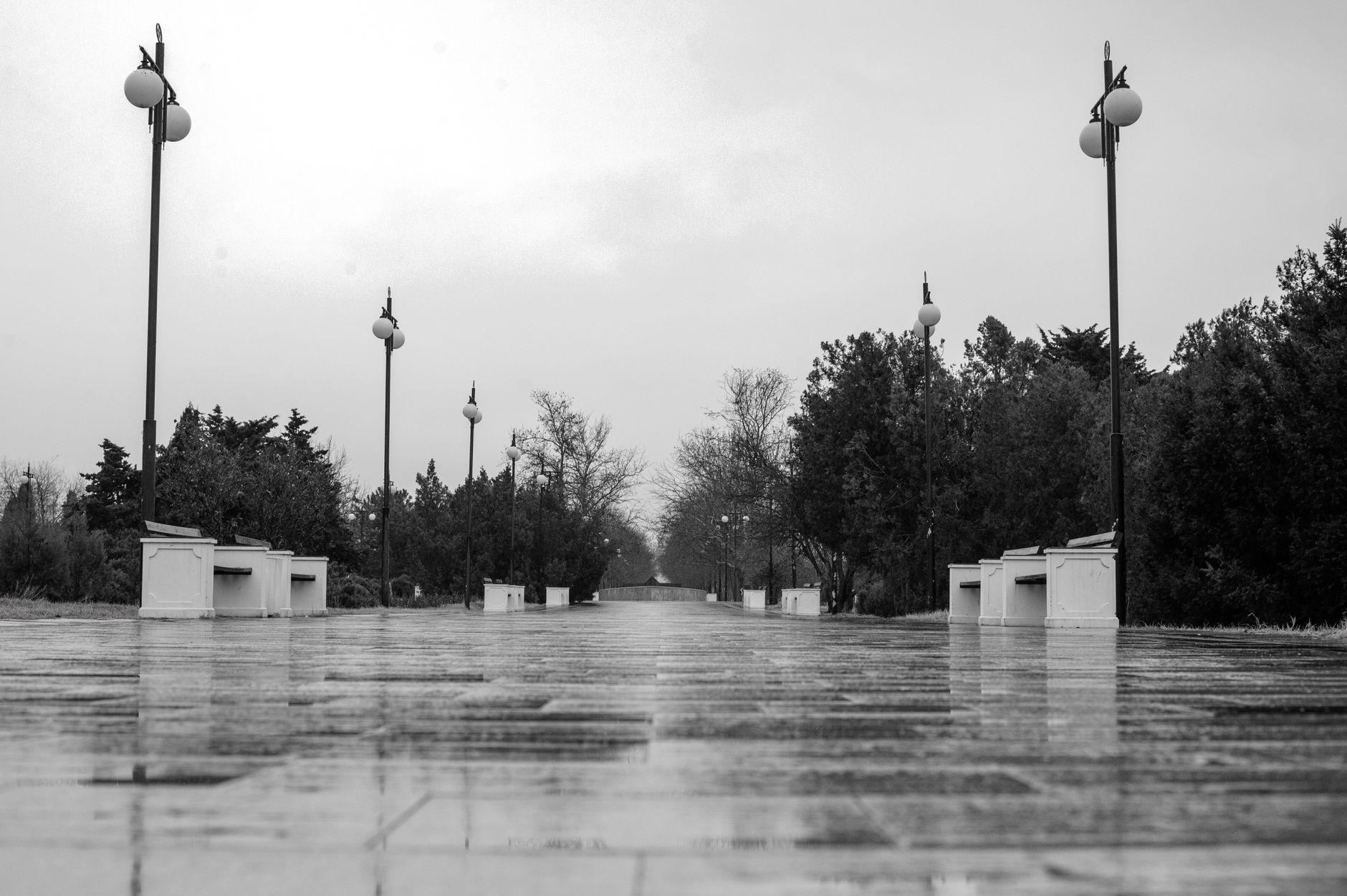 Pedestrians navigate a wet public walkway where traction, obstacle detection, and safe stopping matter.