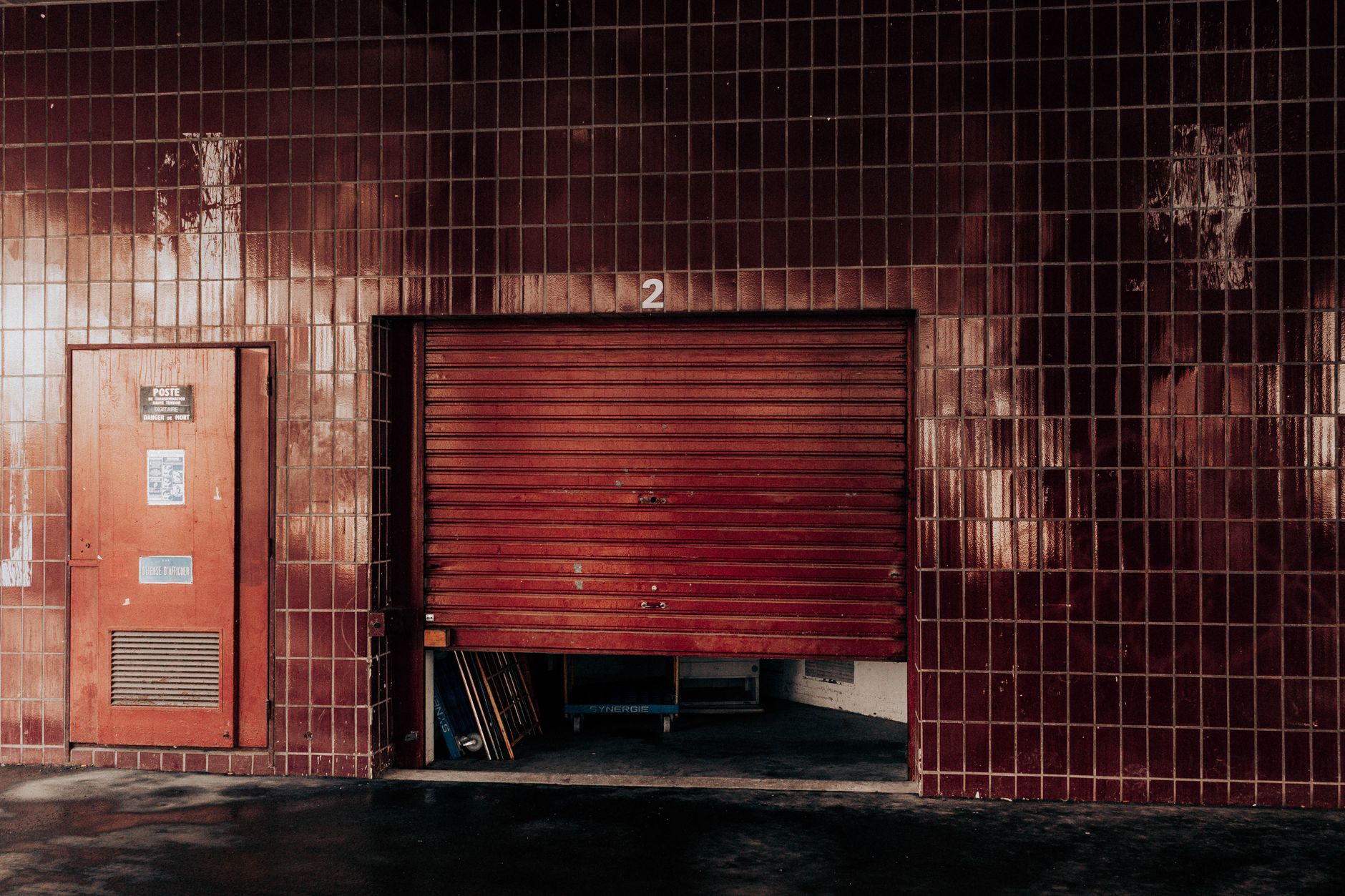 Bright daylight and shadows crossing the threshold of an open vehicle bay door.