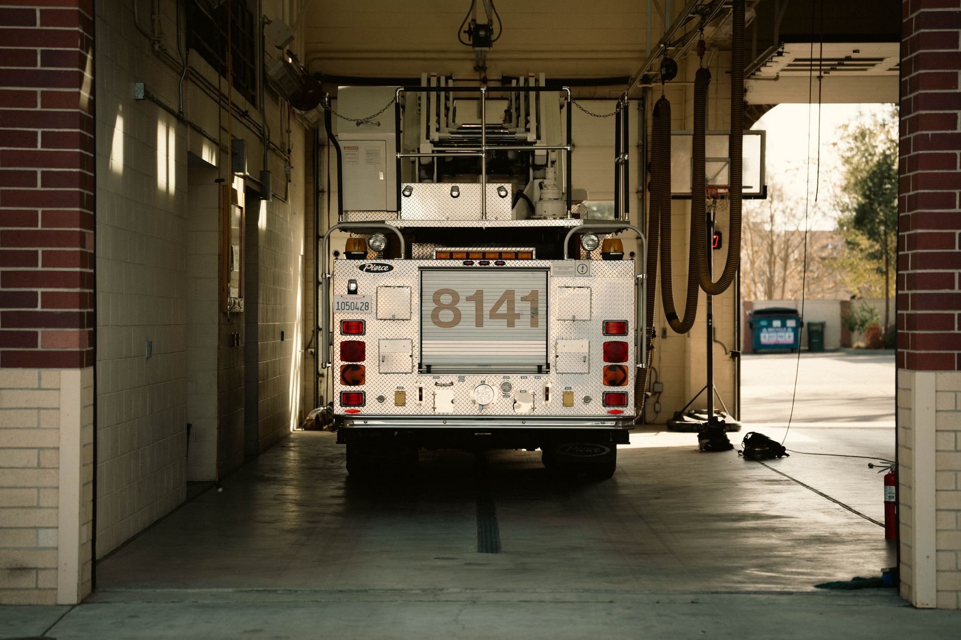 Fire apparatus parked inside a clean, well-lit station bay with clear floor routes.