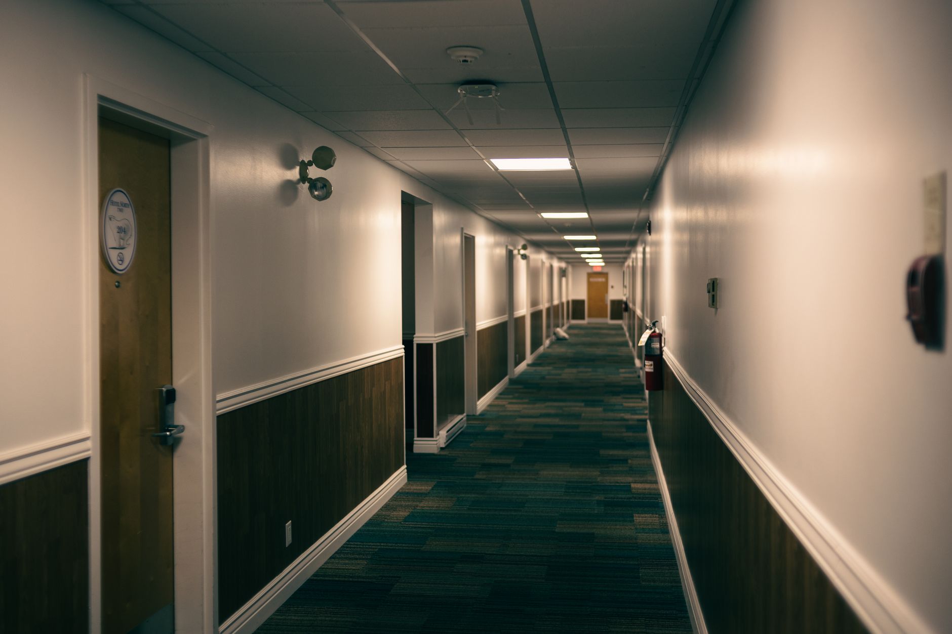 A long, empty, and clean hotel corridor, representing the large floor areas that autonomous cleaning robots can efficiently handle.