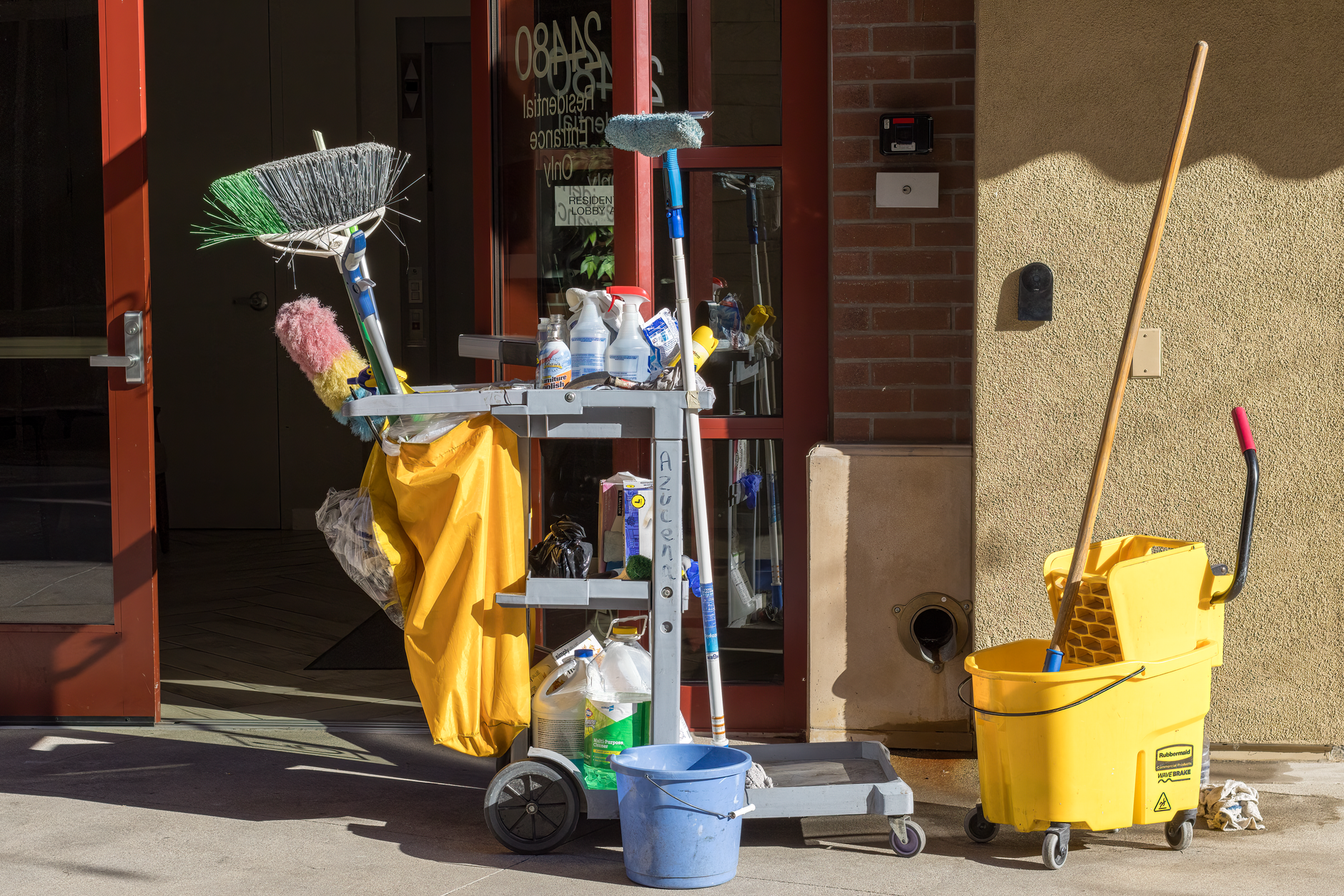 A neatly organized housekeeping cart in a hotel hallway, showing the tools staff use for detailed, high-touch cleaning in guest rooms.
