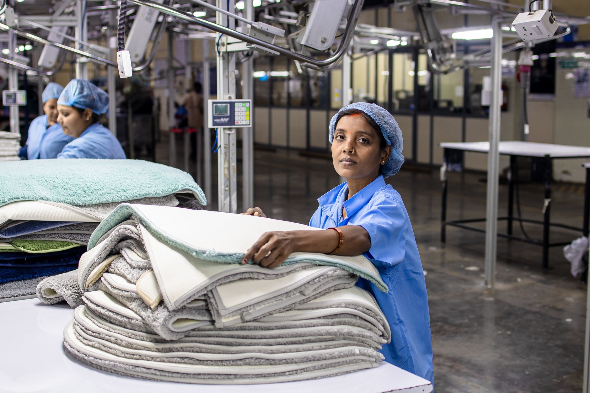 A diverse team of workers collaborates on a clean, modern assembly line, illustrating the human element at the heart of manufacturing.
