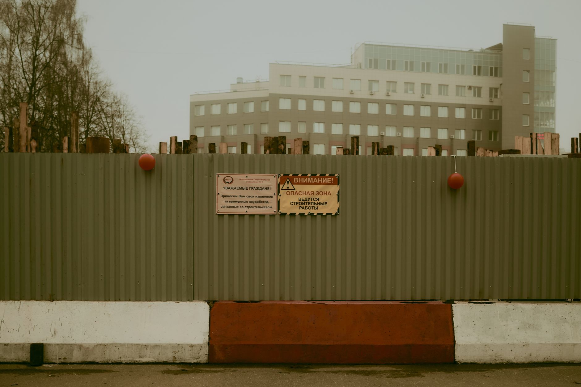 A fenced commercial construction site at dusk, showing the exposed perimeter and access points that need layered protection.