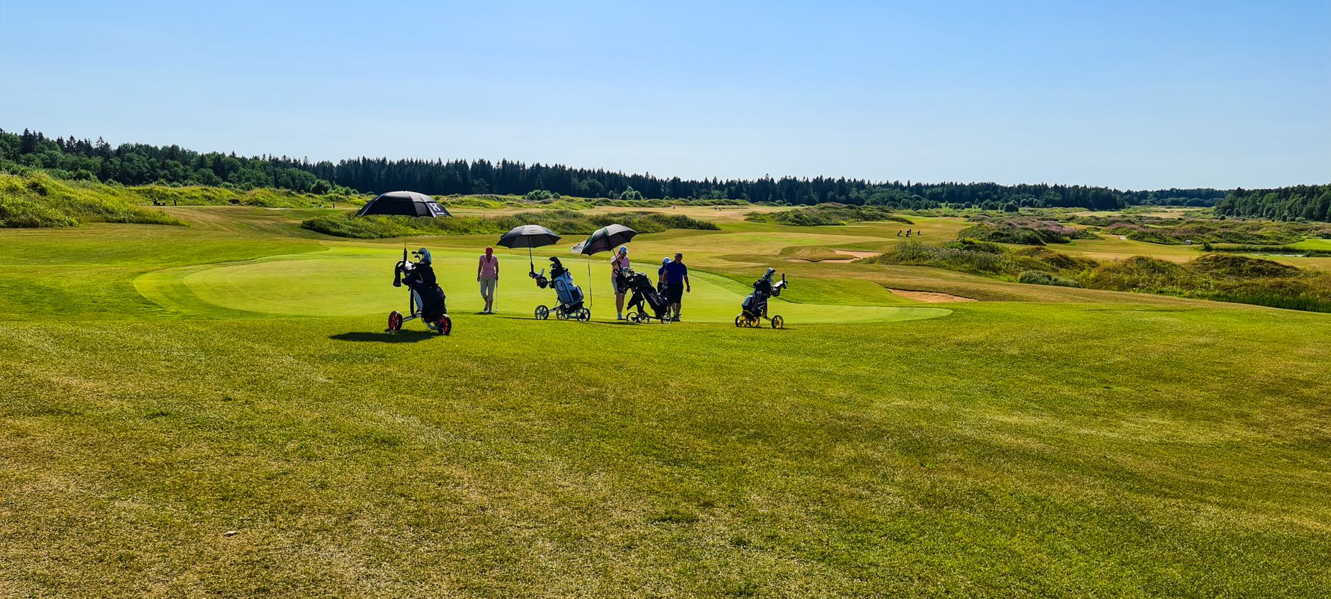 Sponsor tents staged along fairway margins before a charity scramble.