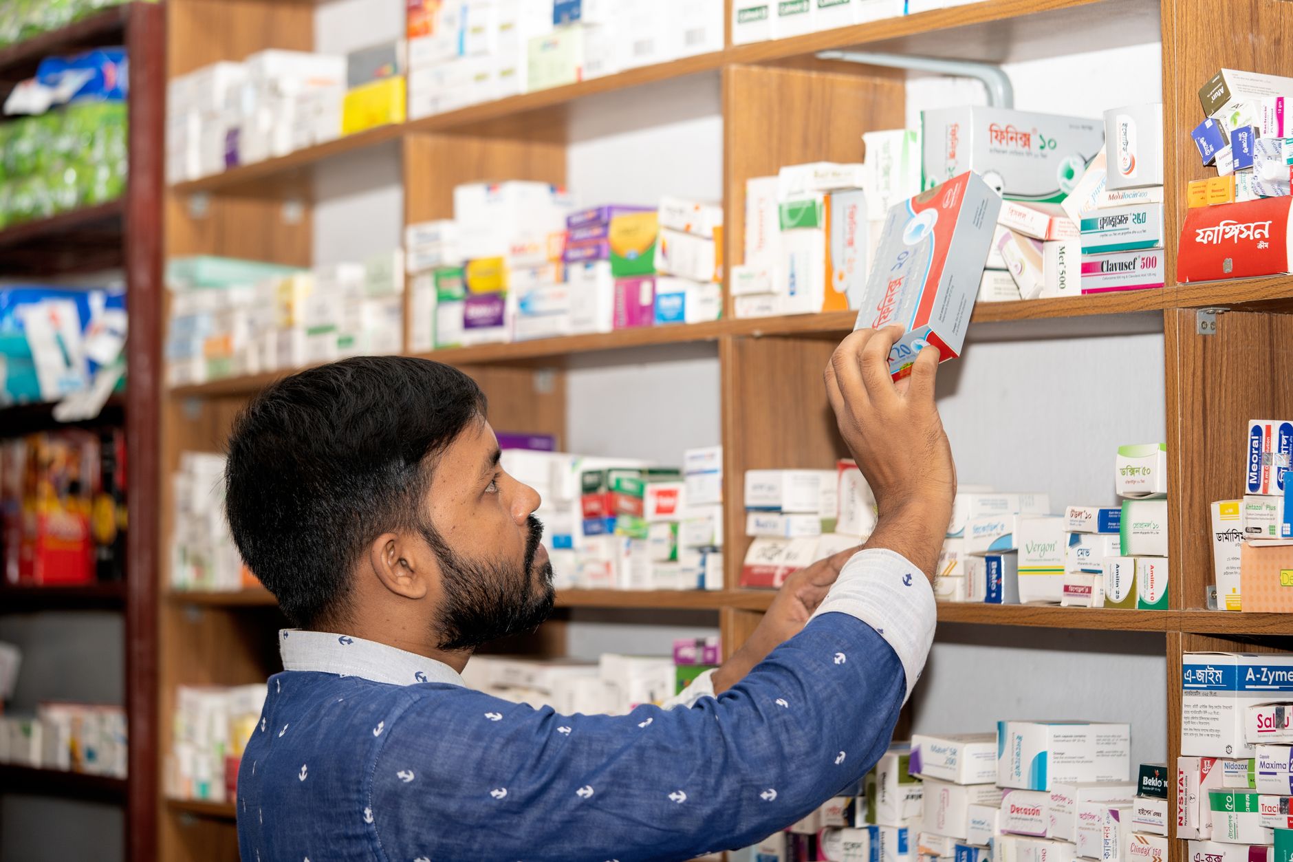 Neatly stocked pharmacy shelves with labeled boxes, the kind of supply area where staff time can be measured before and after a change.