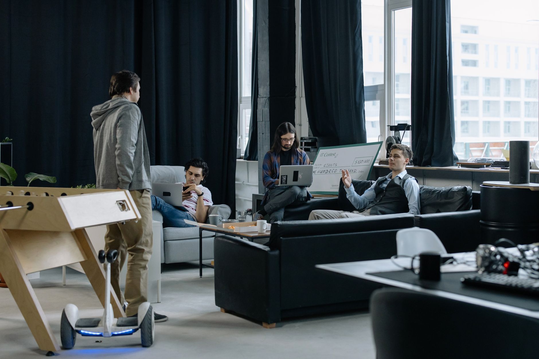 A bright modern coworking space with open desks, clear walkways, and members working throughout the room.