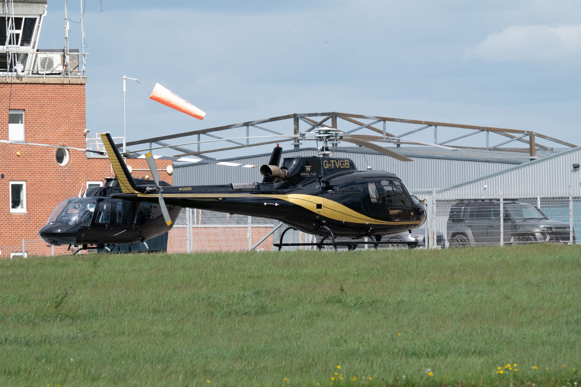 A wind cone beside an elevated helipad, visible against the open sky.