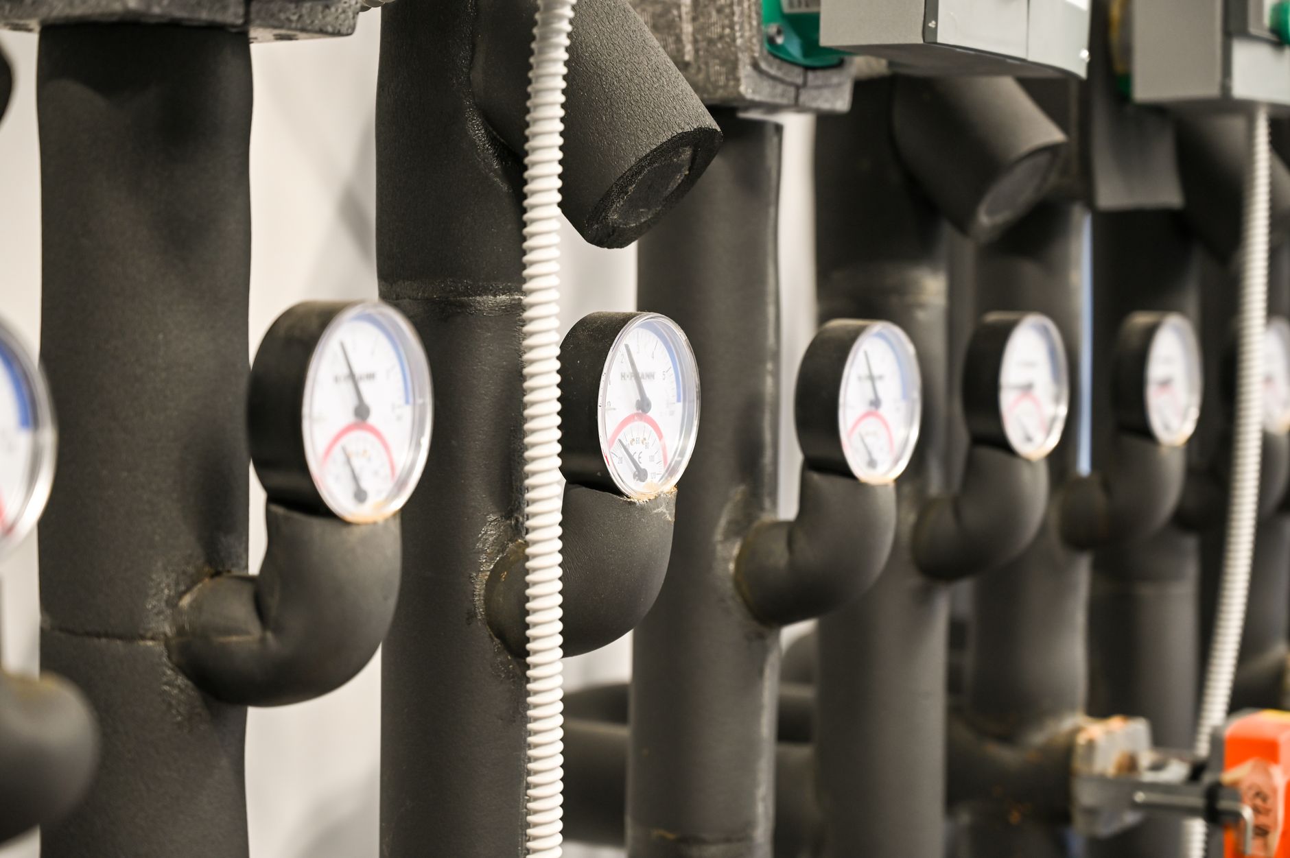 Close view of industrial pressure gauges and piping, like the analog indicators a telecom inspection round still has to read clearly.
