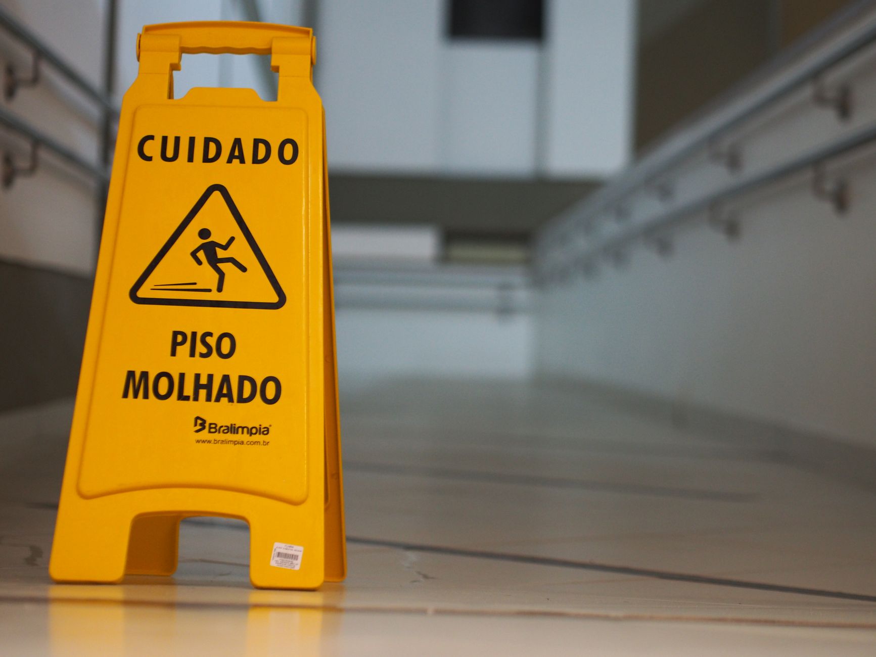 A damp commercial corridor floor with reflections and tight edges, showing why moisture control and dry finishes matter in cultivation-adjacent spaces.