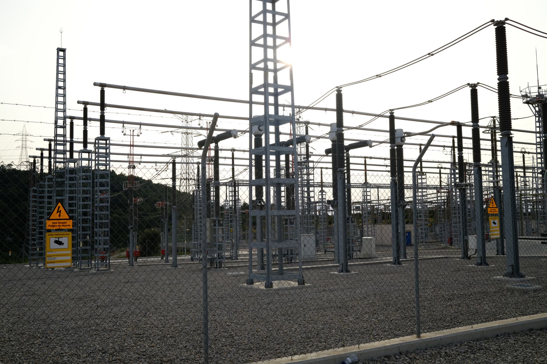 An outdoor power plant switchyard with gravel and concrete blocks, showing the kind of uneven terrain a robot must navigate.