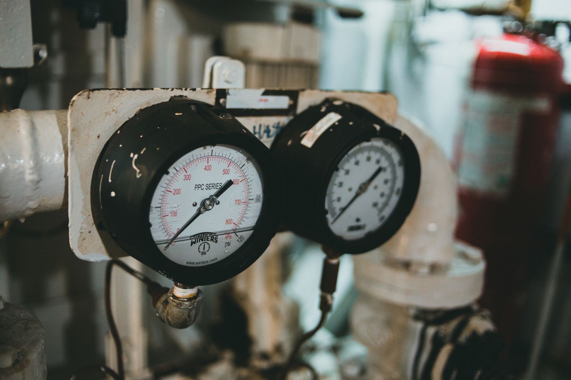 A closeup of several pressure and temperature gauges on industrial machinery, representing robotic sensor payloads.