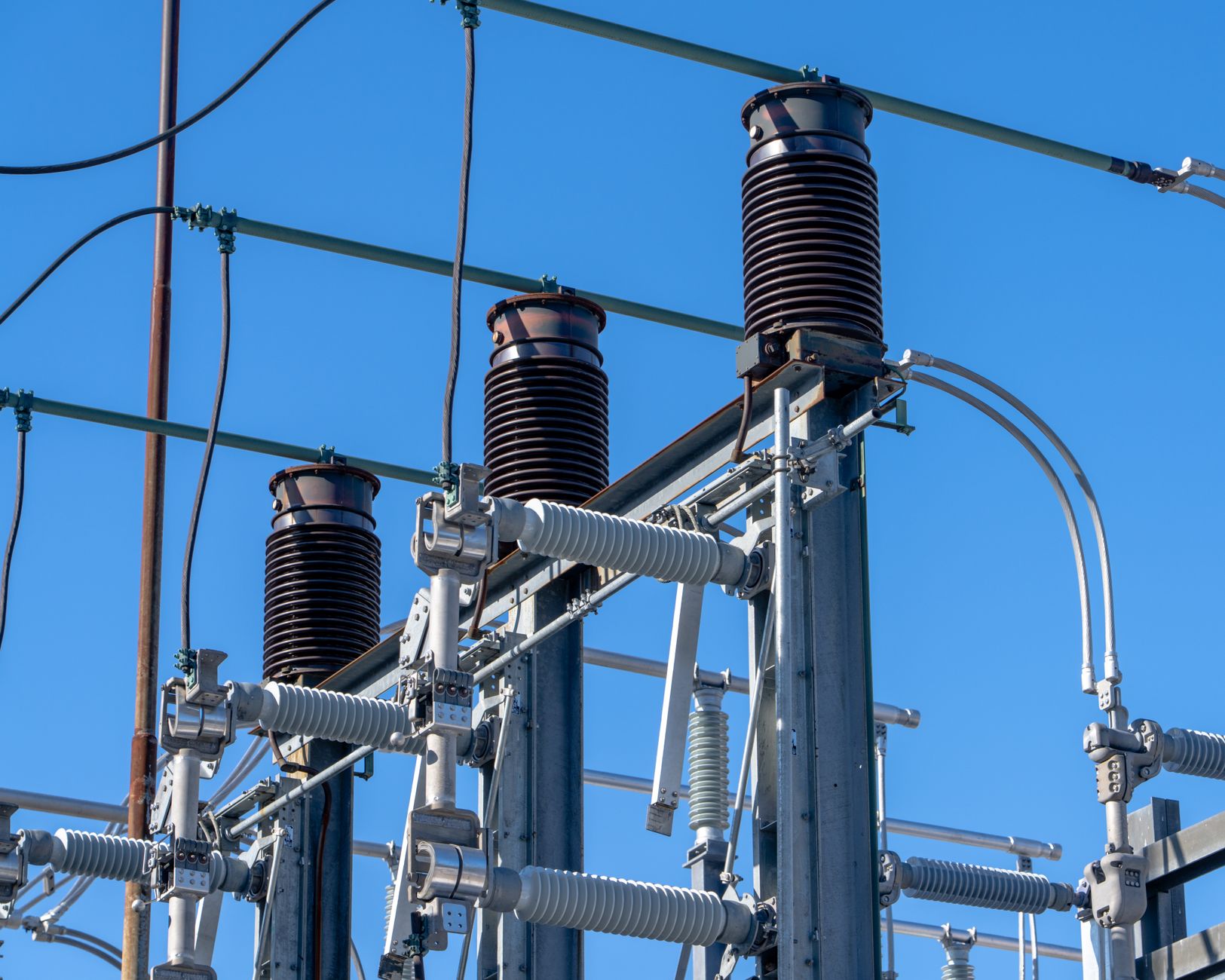 A row of large ceramic insulators on a high-voltage power line, a critical component that requires robotic cleaning.
