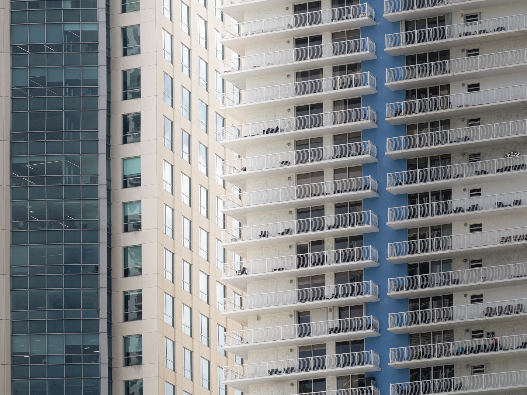 The complex facade of a modern building, showing a mix of glass, balconies, and ledges that pose a challenge for automated cleaning systems.
