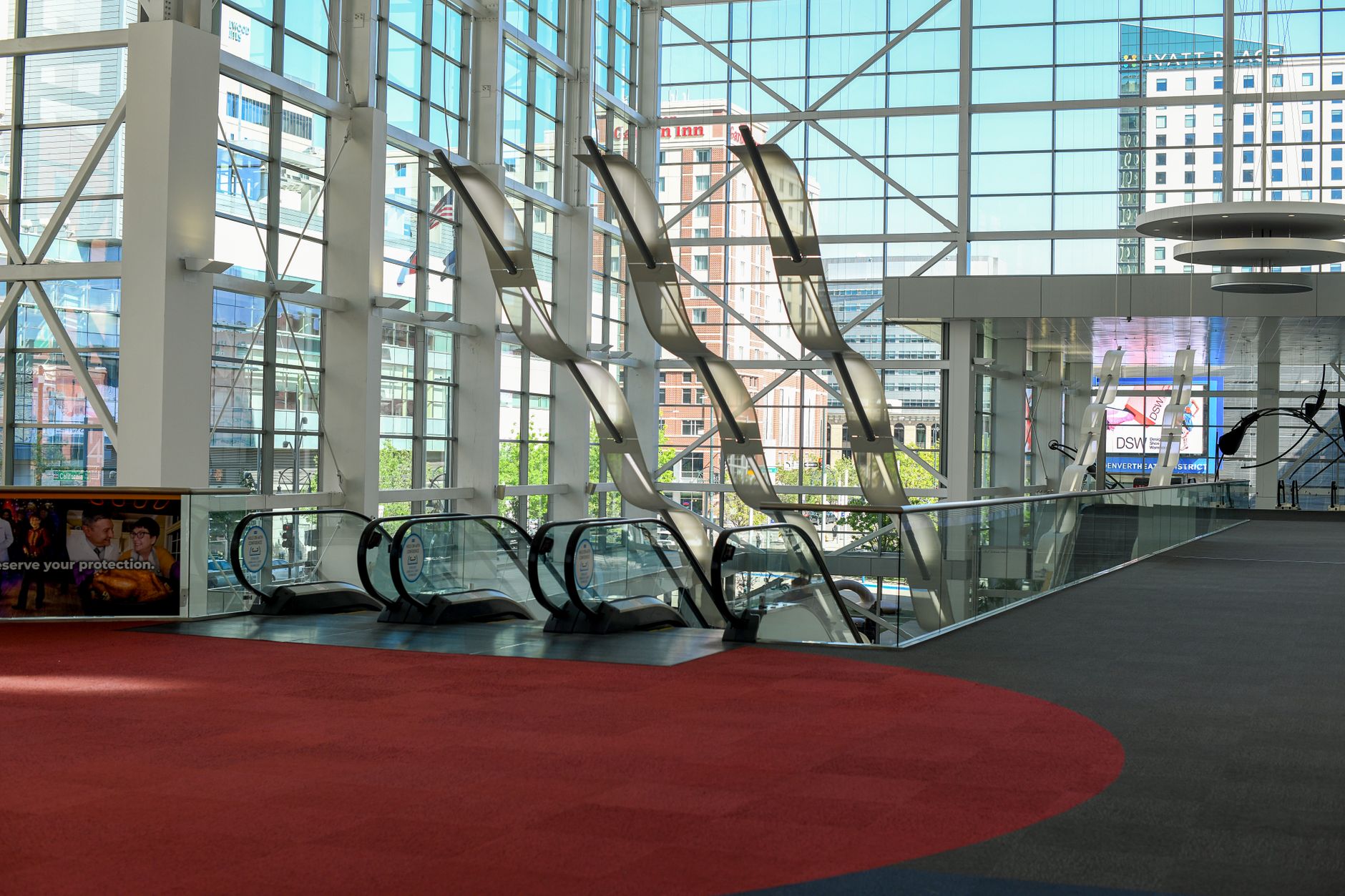 The patterned carpet of a large convention center lobby meeting a polished hard floor surface, illustrating the different materials robotic cleaners must handle.