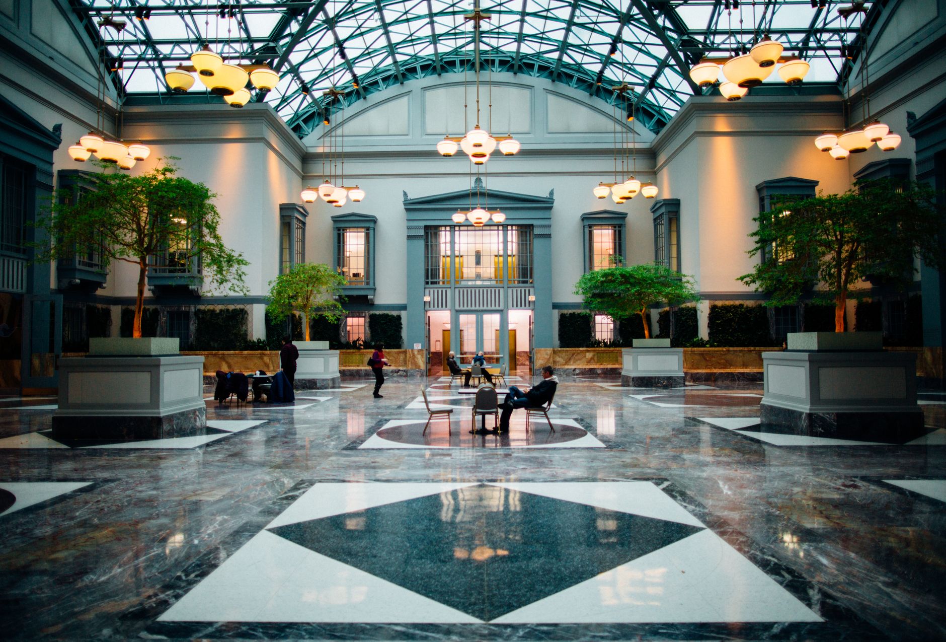 A janitor mops a hotel lobby floor during a quiet operating window.