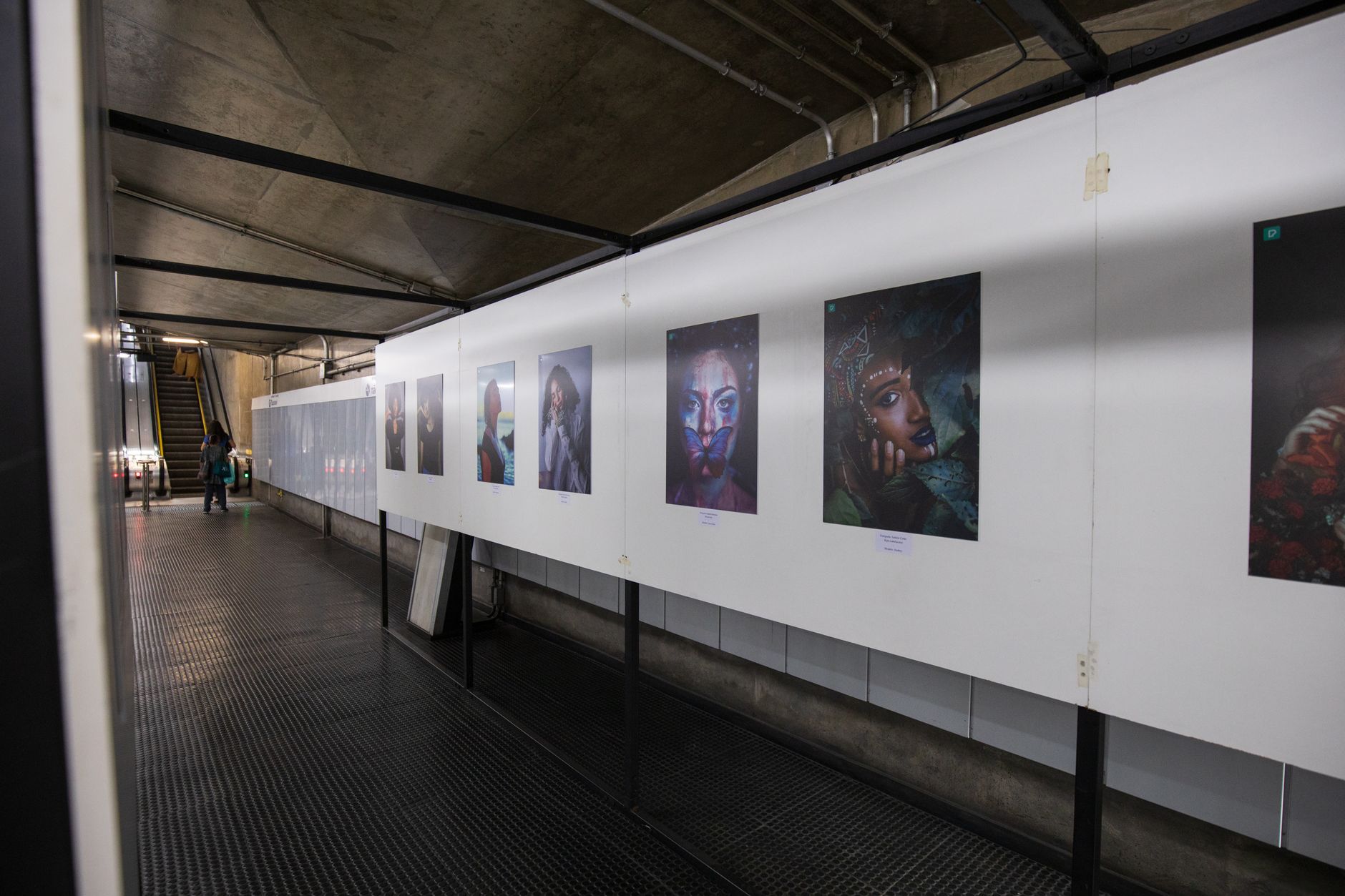 Exhibition staff arrange artwork and temporary displays in a gallery whose layout is still changing.