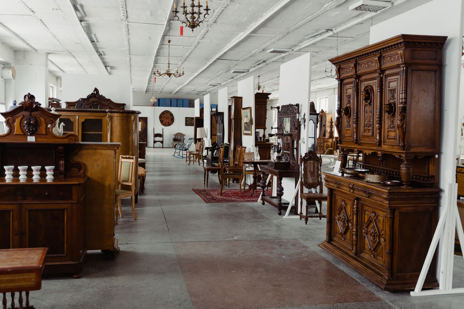 Delicate antique furniture stands closely arranged inside a carefully presented showroom.