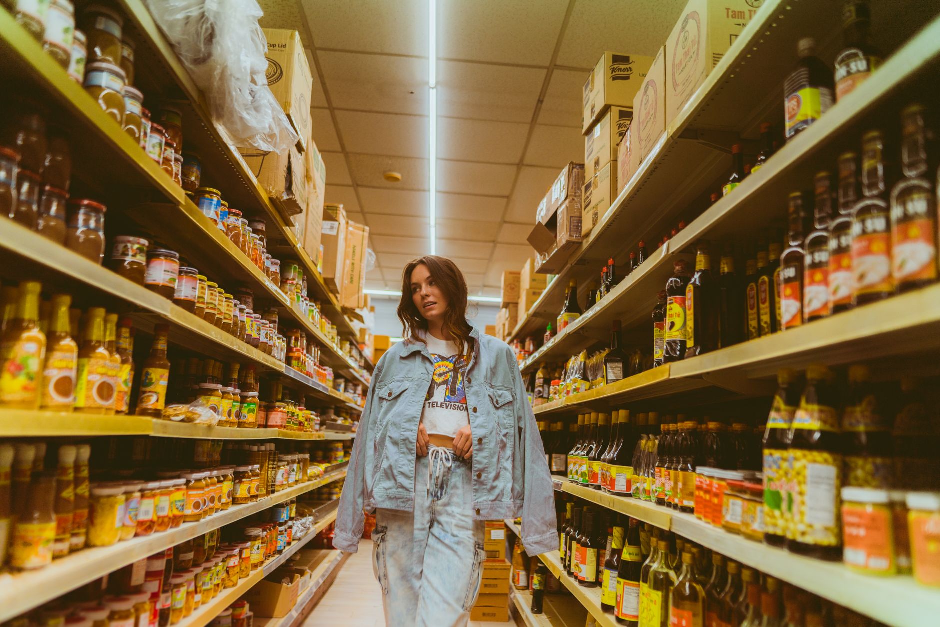 A bright retail aisle with stocked shelves, similar to the hard-floor zones a scrubber would cover after close.
