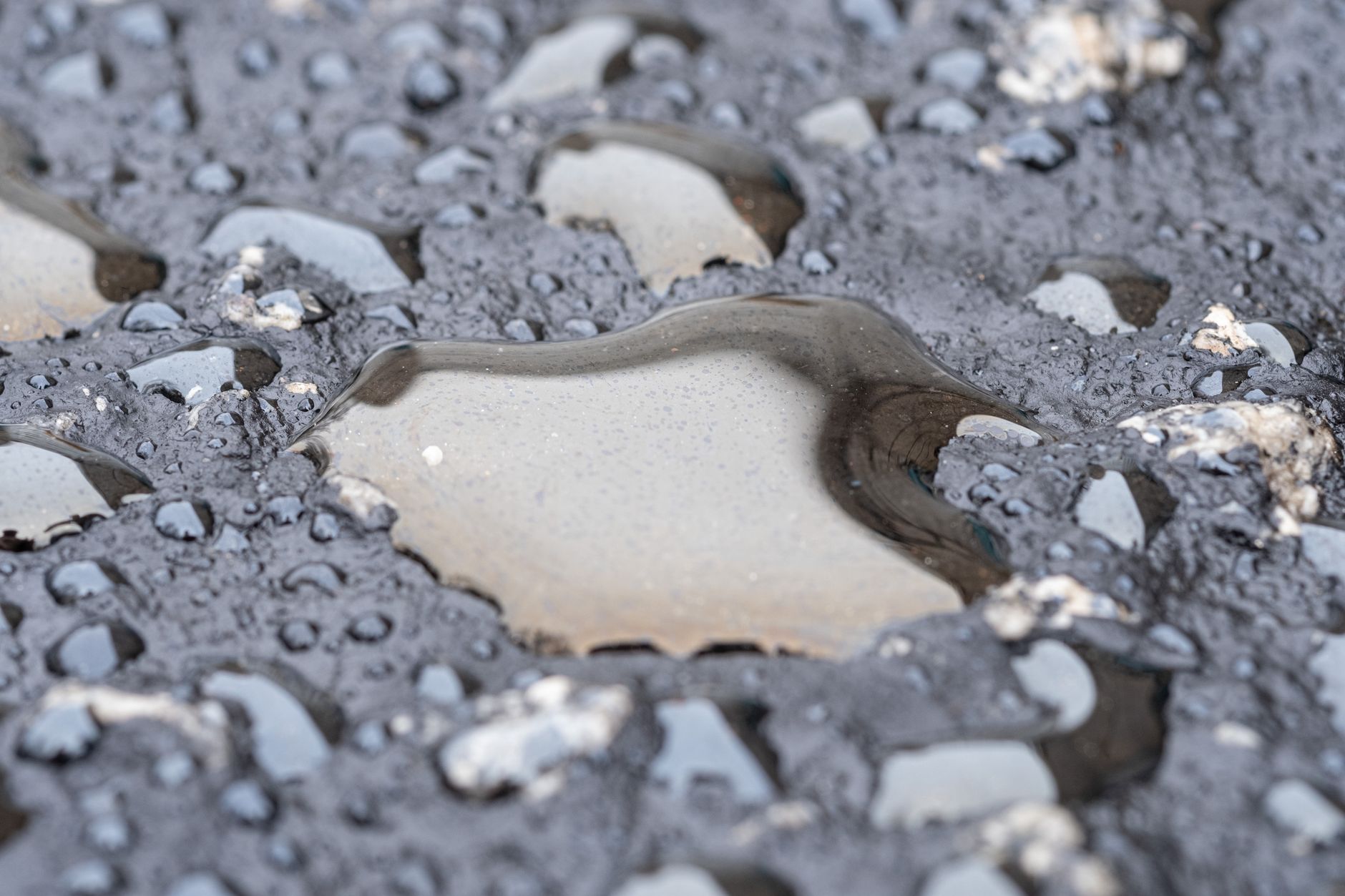 A worker applying absorbent material to a fluid spill on a workshop floor.
