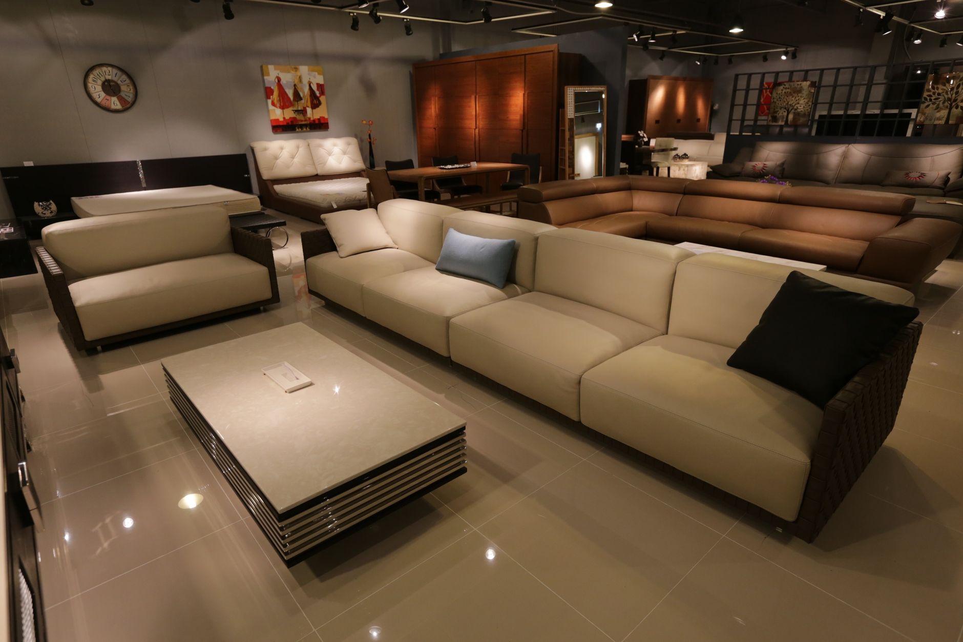 A polished flooring showroom displays tile, wood and resilient floor samples under bright retail lighting.