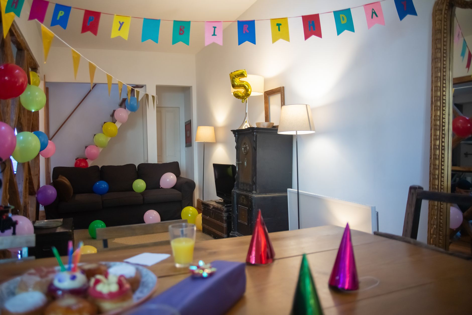 A decorated party room with tables and snacks, echoing the crumbs and spills that reach mini-golf entries after group events.