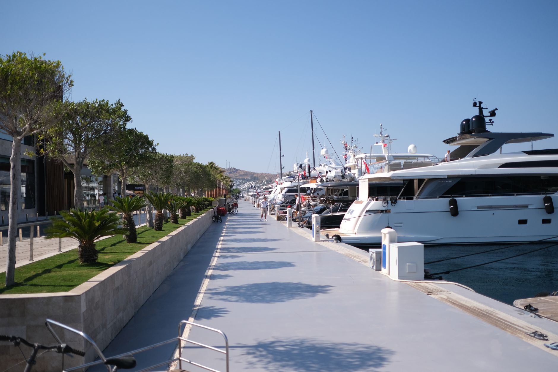 Wooden marina dock with boats moored alongside, showing the wet deck environment bathhouse floors face.