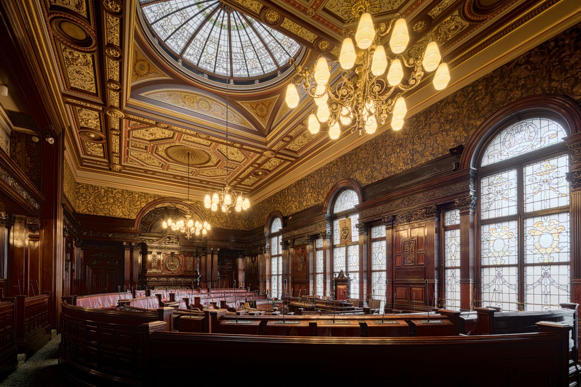 An empty council chamber arranged for a public meeting, with rows of seating and open aisles.