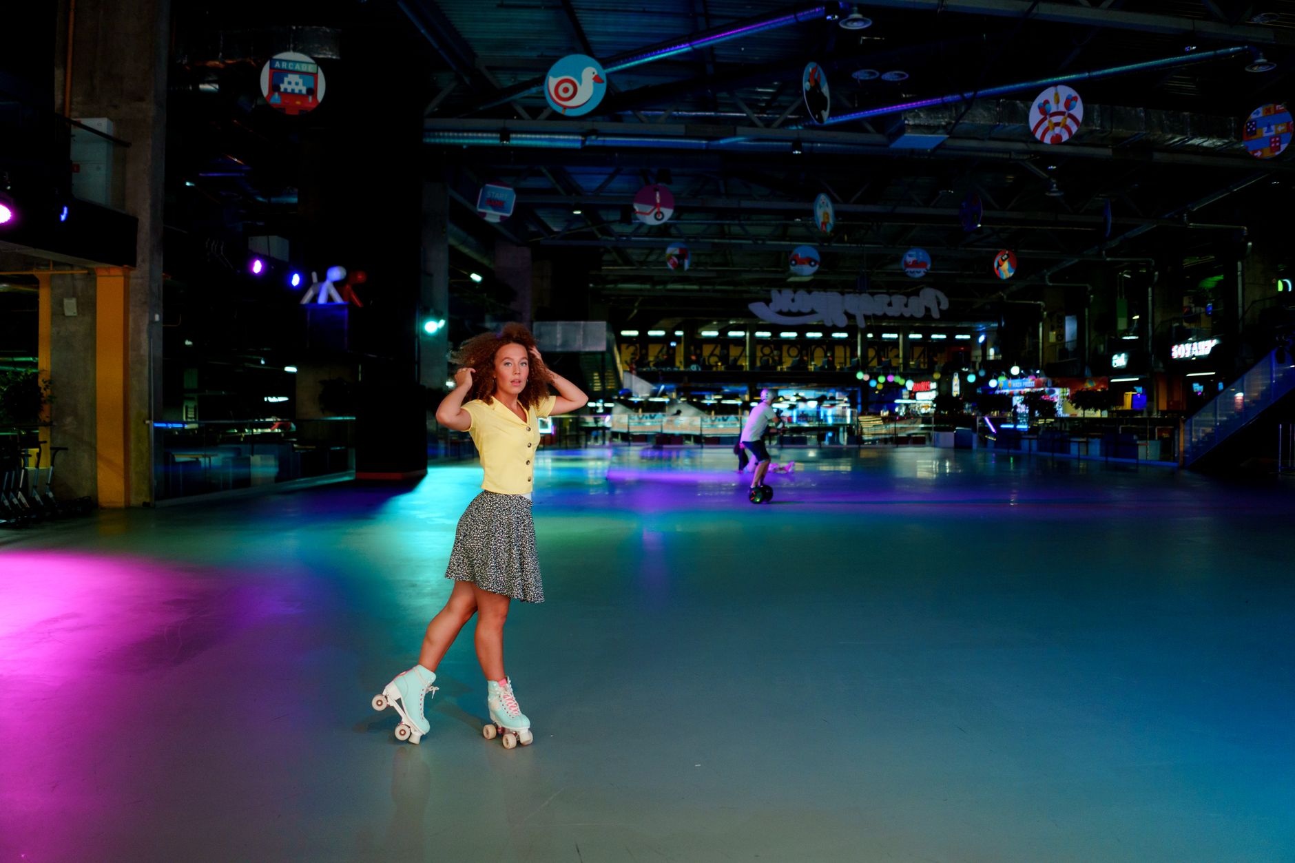 An empty indoor roller rink after close with the coated skating floor and surrounding venue visible.