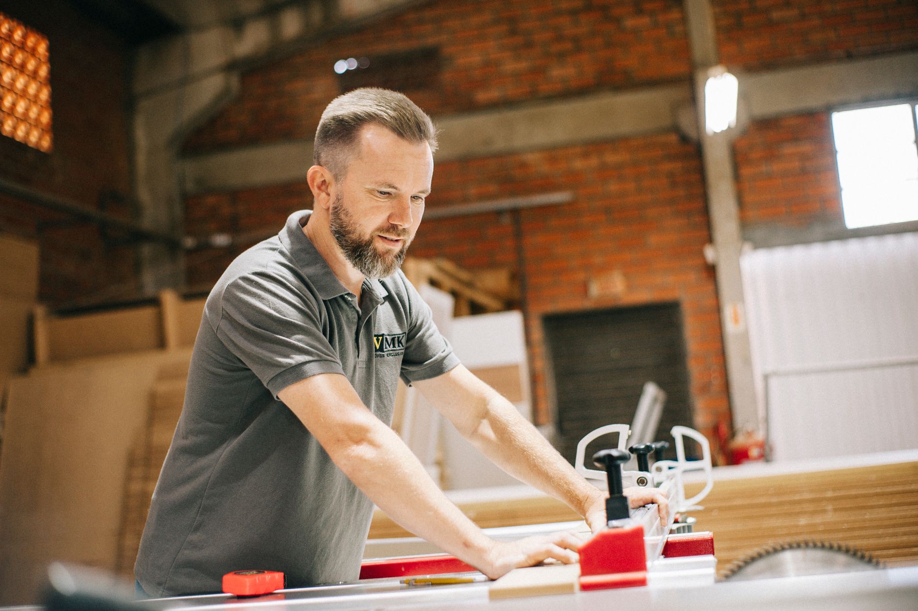 A skilled fabricator works on a custom commercial sign in a busy production workshop.