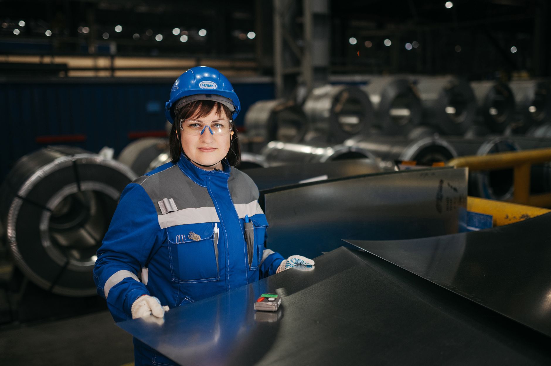 A factory technician inspects industrial equipment during a maintenance check.