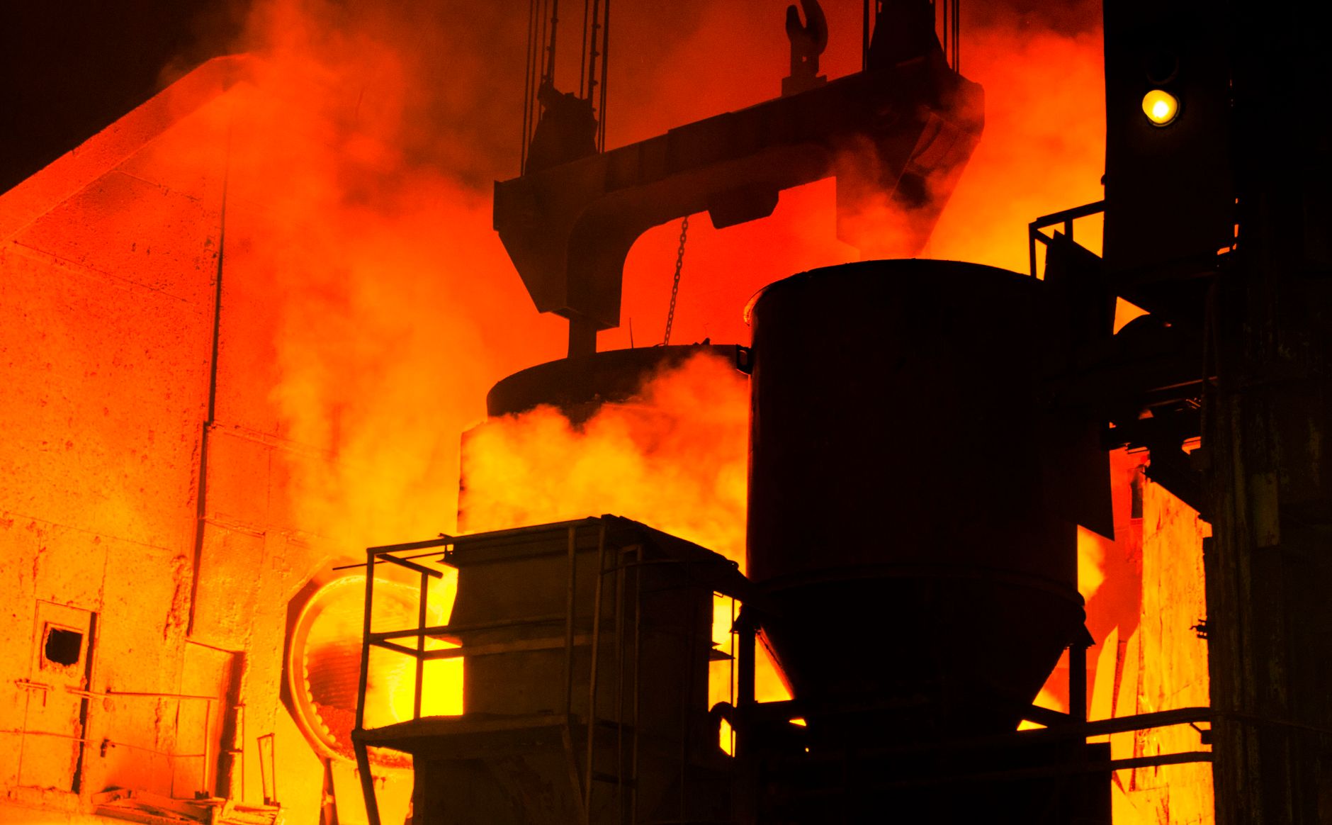 An open industrial furnace glows inside a metal heat-treatment workspace.