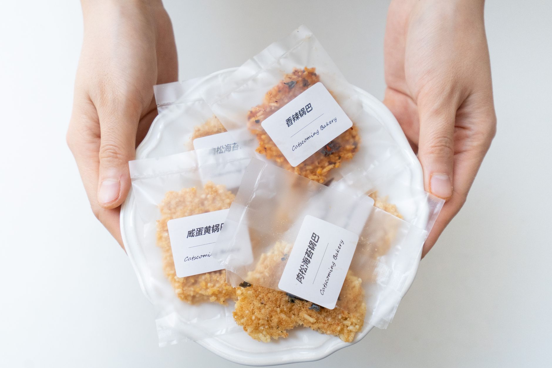 Workers pack baked goods along a commercial bakery line, showing the kind of repetitive handoff work discussed in the article.