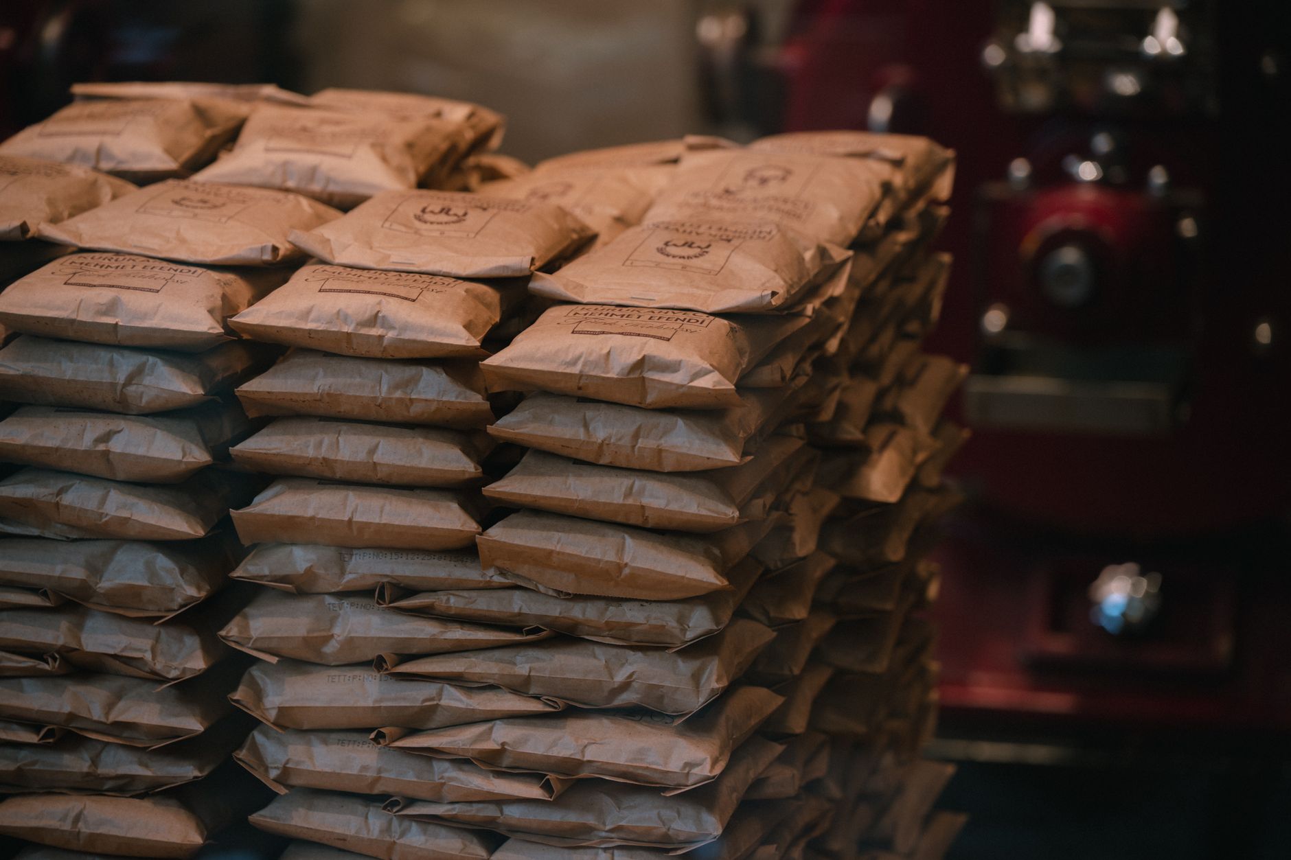Stacks of filled seed and animal feed bags arranged on pallets inside an agricultural warehouse.