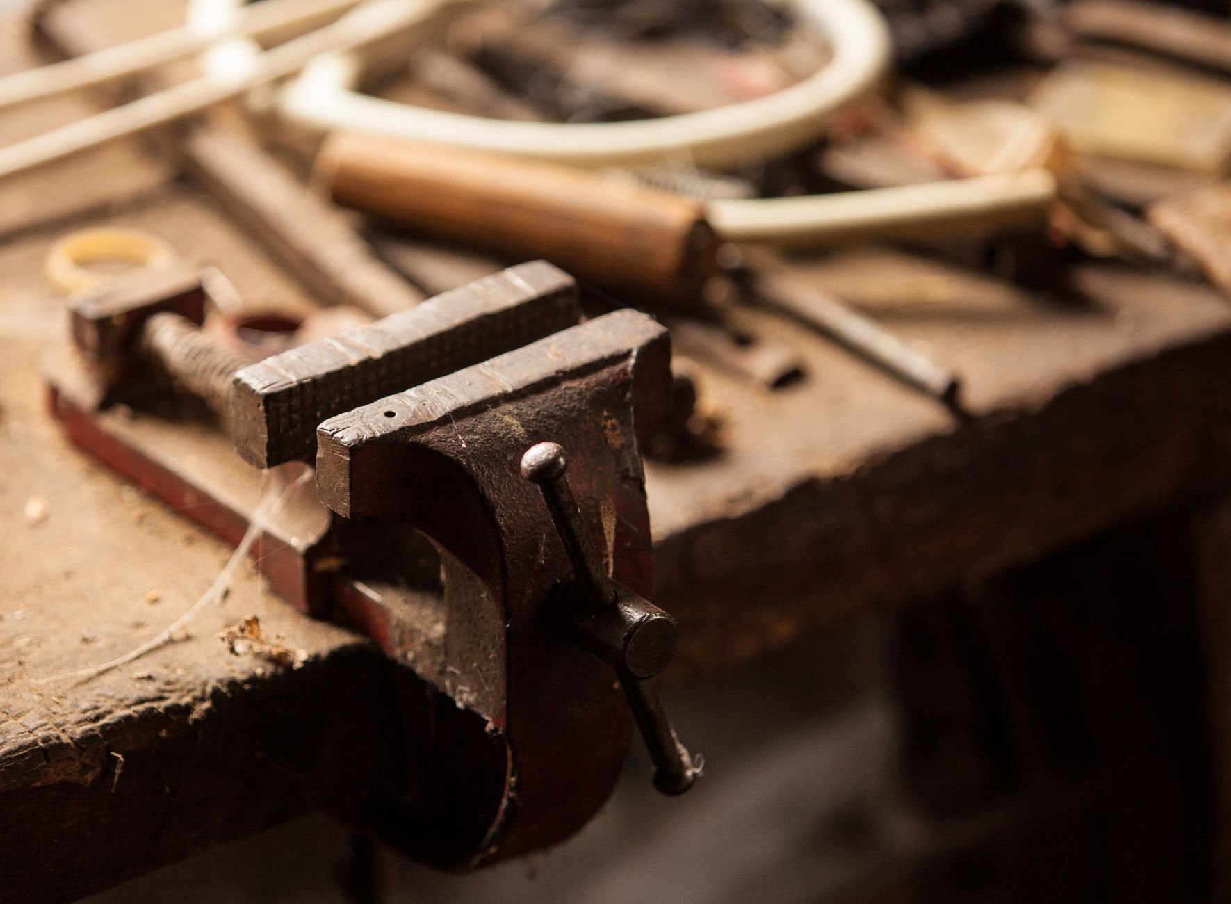 A vice and clamps on a metal workbench show the hard tooling and precise locating that dedicated multi-spindle fastening depends on.
