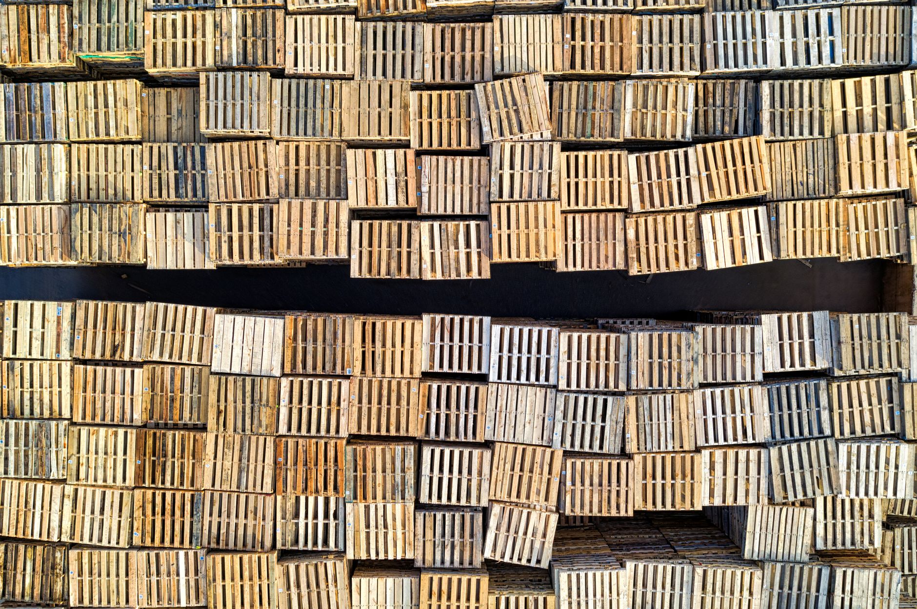 Long rows of palletized inventory in a distribution aisle, illustrating throughput pressure at the wrap station.