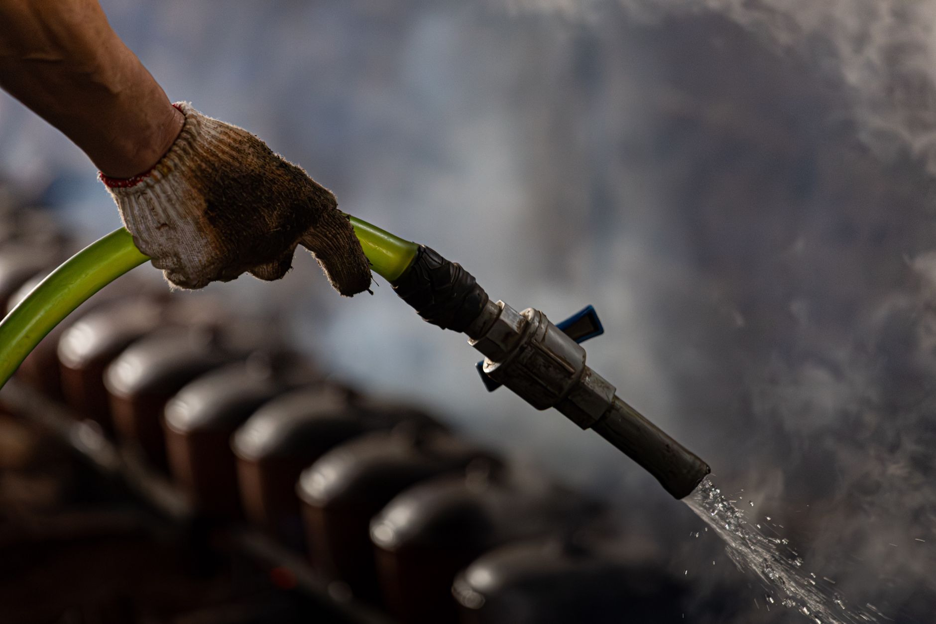 Close-up of worn industrial hose and protective hardware exposed to abrasive working conditions.