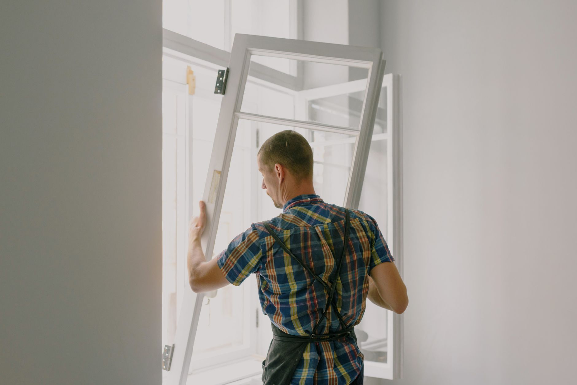 Large glass panels handled carefully, where edge alignment prevents bubbles under protective film.