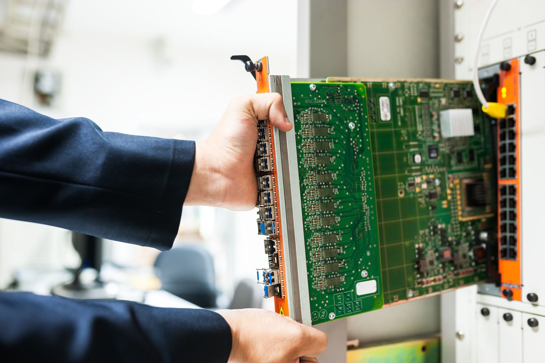 Assembler working at a bench with electrical enclosures, tools, and wire bundles ready for junction-box work.