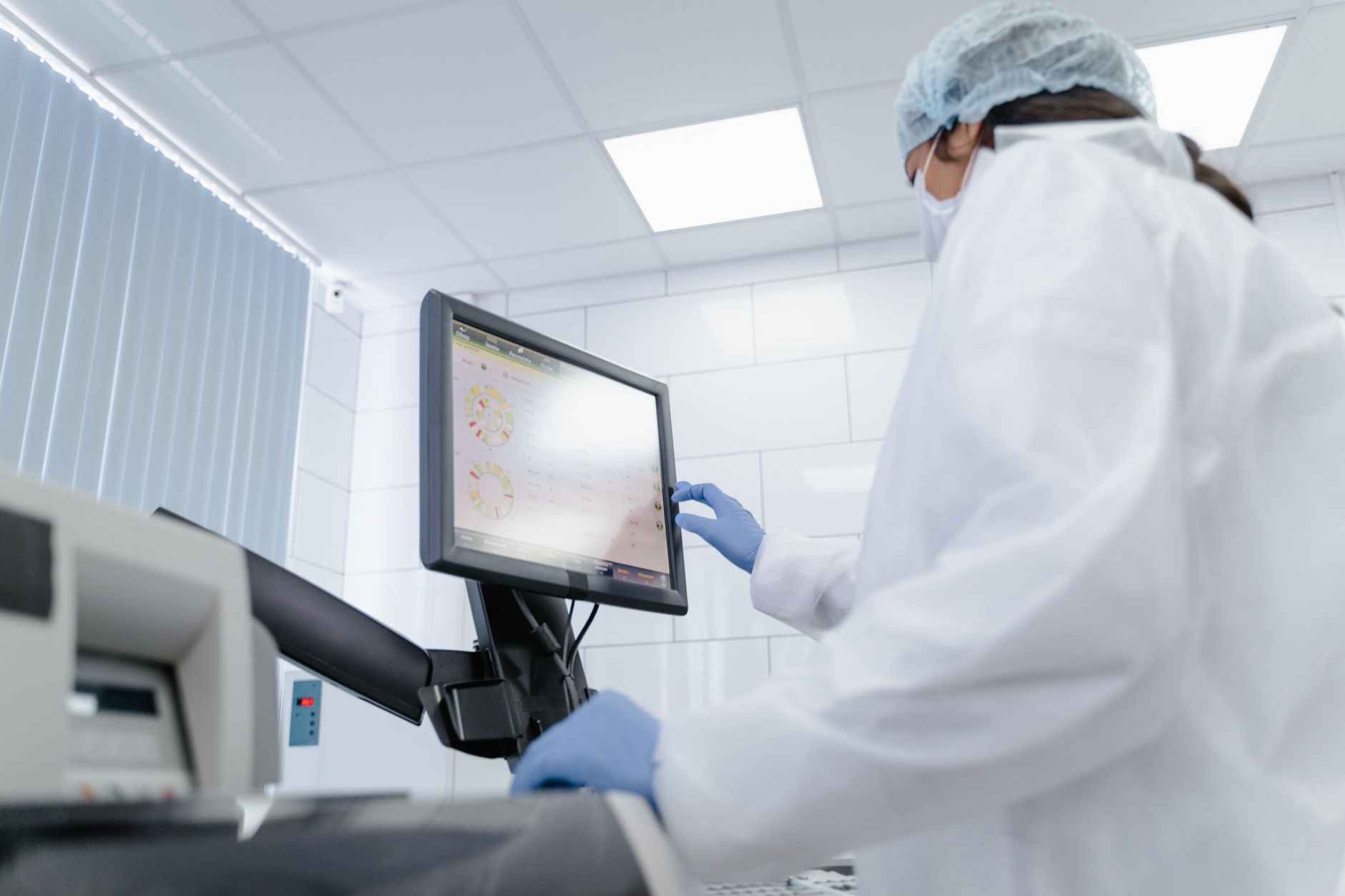 A gloved technician works in a clean production environment designed to protect sensitive materials from contamination.