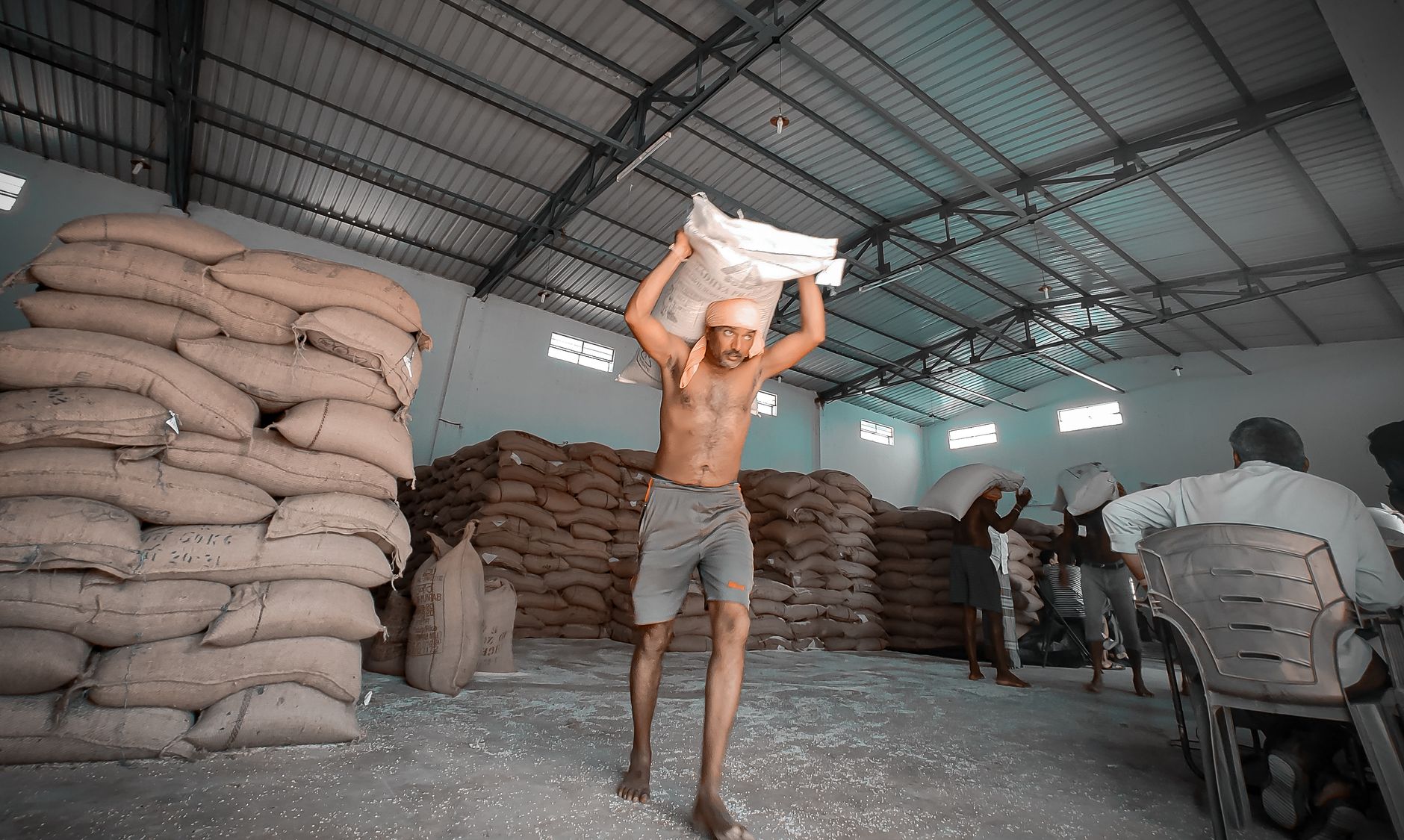Stacked ingredient sacks on a pallet in a food plant storage area awaiting bag opening and dumping.