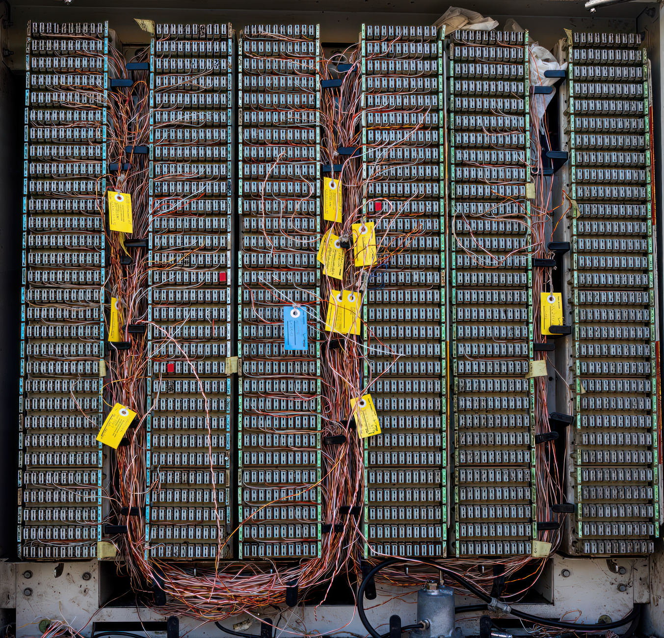 Printed identification labels distinguish individual conductors in a bundle of control-panel wiring.