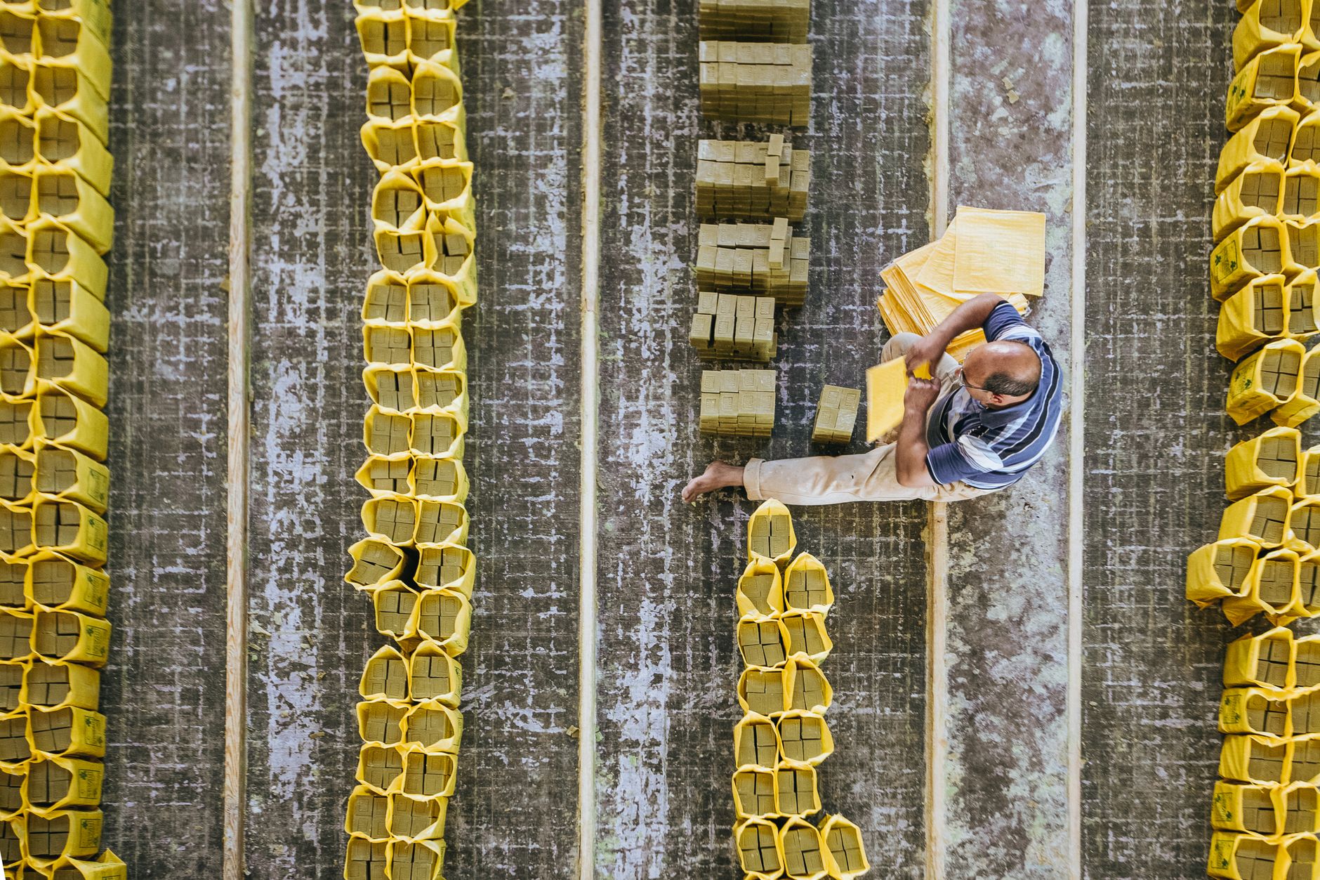 A busy packaging plant floor with conveyors and cartons, illustrating how stalled case erecting starves downstream steps.