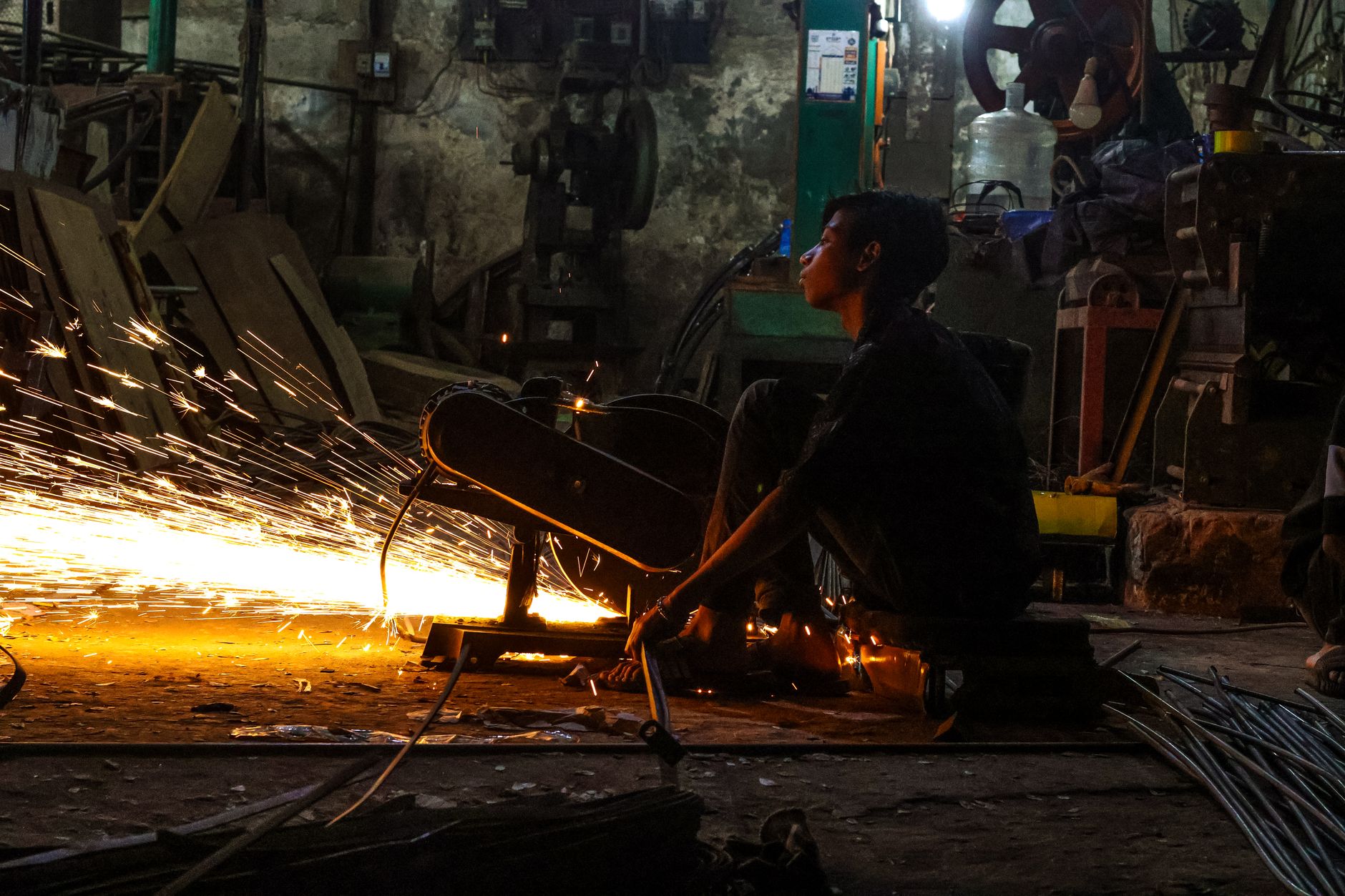 A factory worker on a production shift, illustrating the staffing pressure that pushes molders to revisit repetitive press-side work.