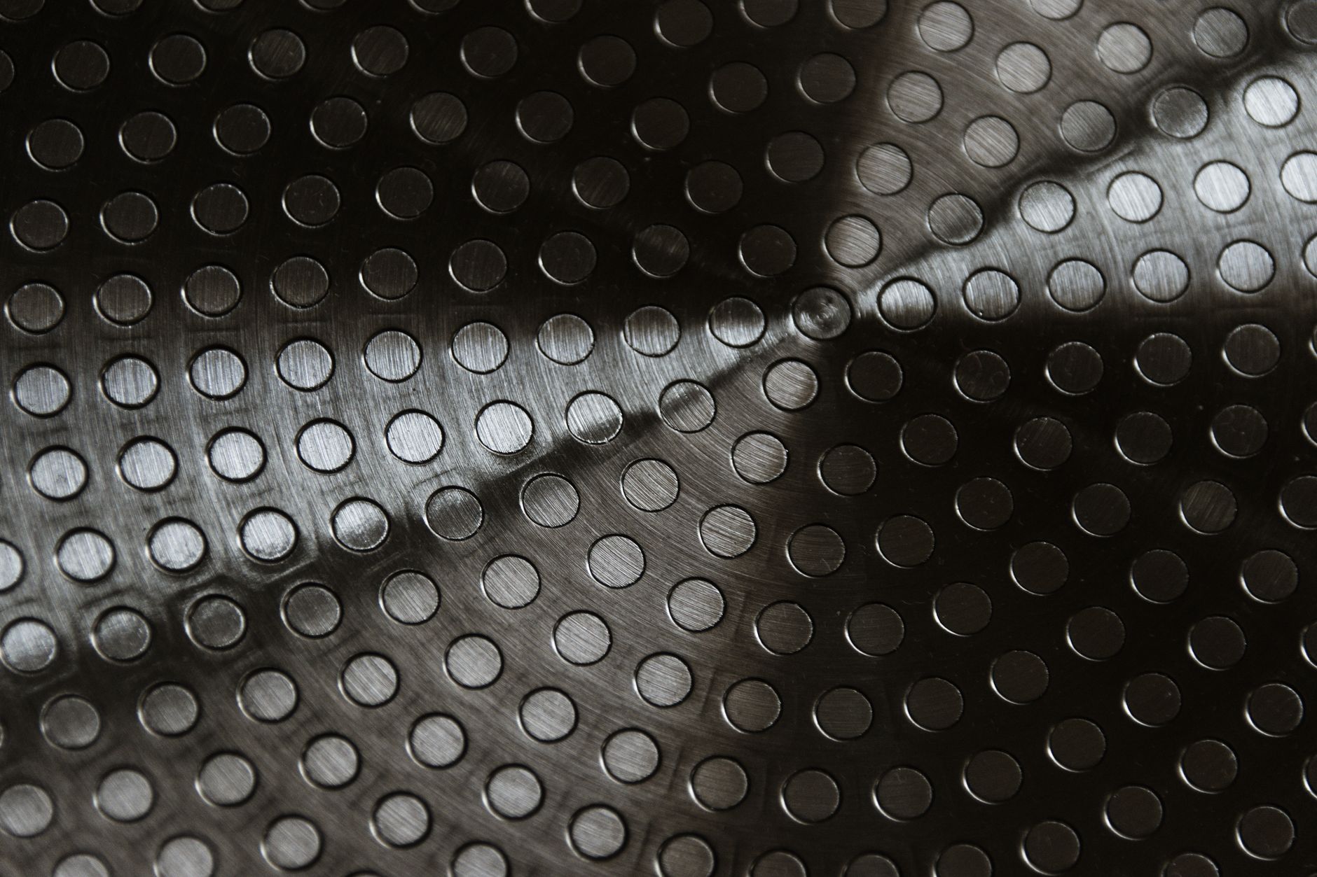 Reflections and highlights across a polished curved metal surface illustrate the imaging challenges posed by surgical instruments.