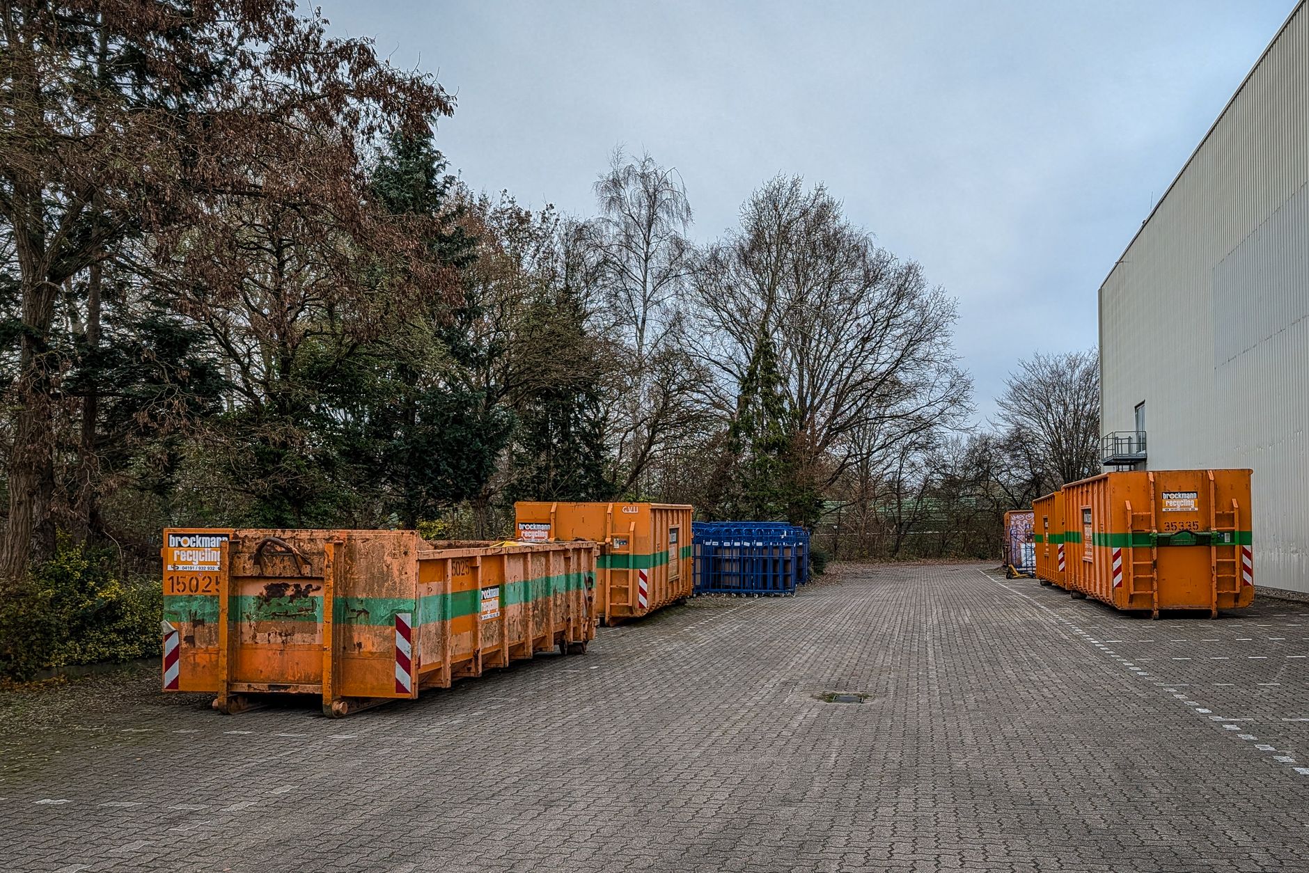 Metal bins and baskets staged in a plant, illustrating the racks and dunnage loaders must align before a wash cycle.