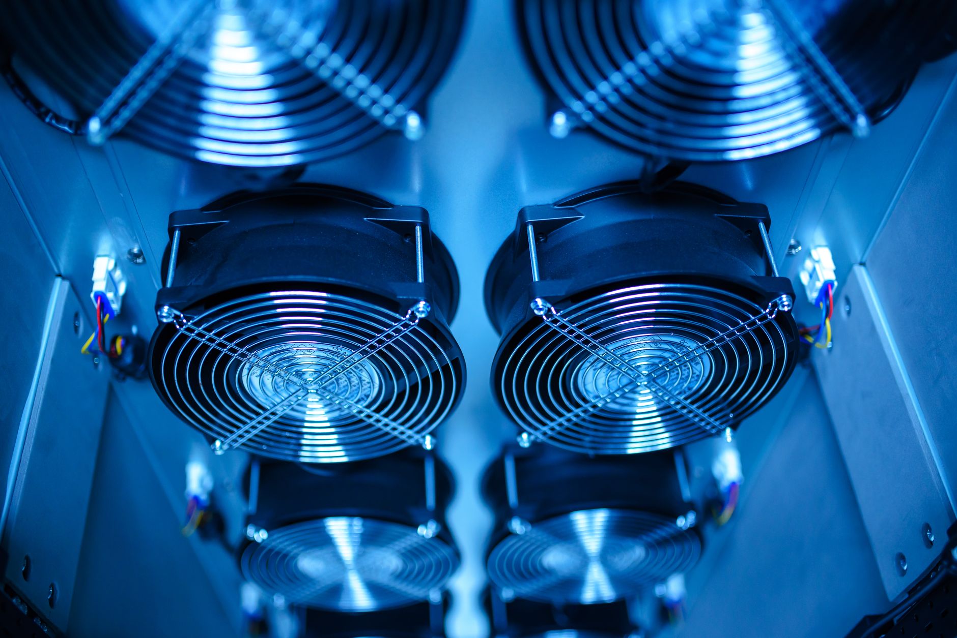 Industrial fans and ductwork near production equipment, evoking drip and cool-down buffers after hot parts leave a washer.