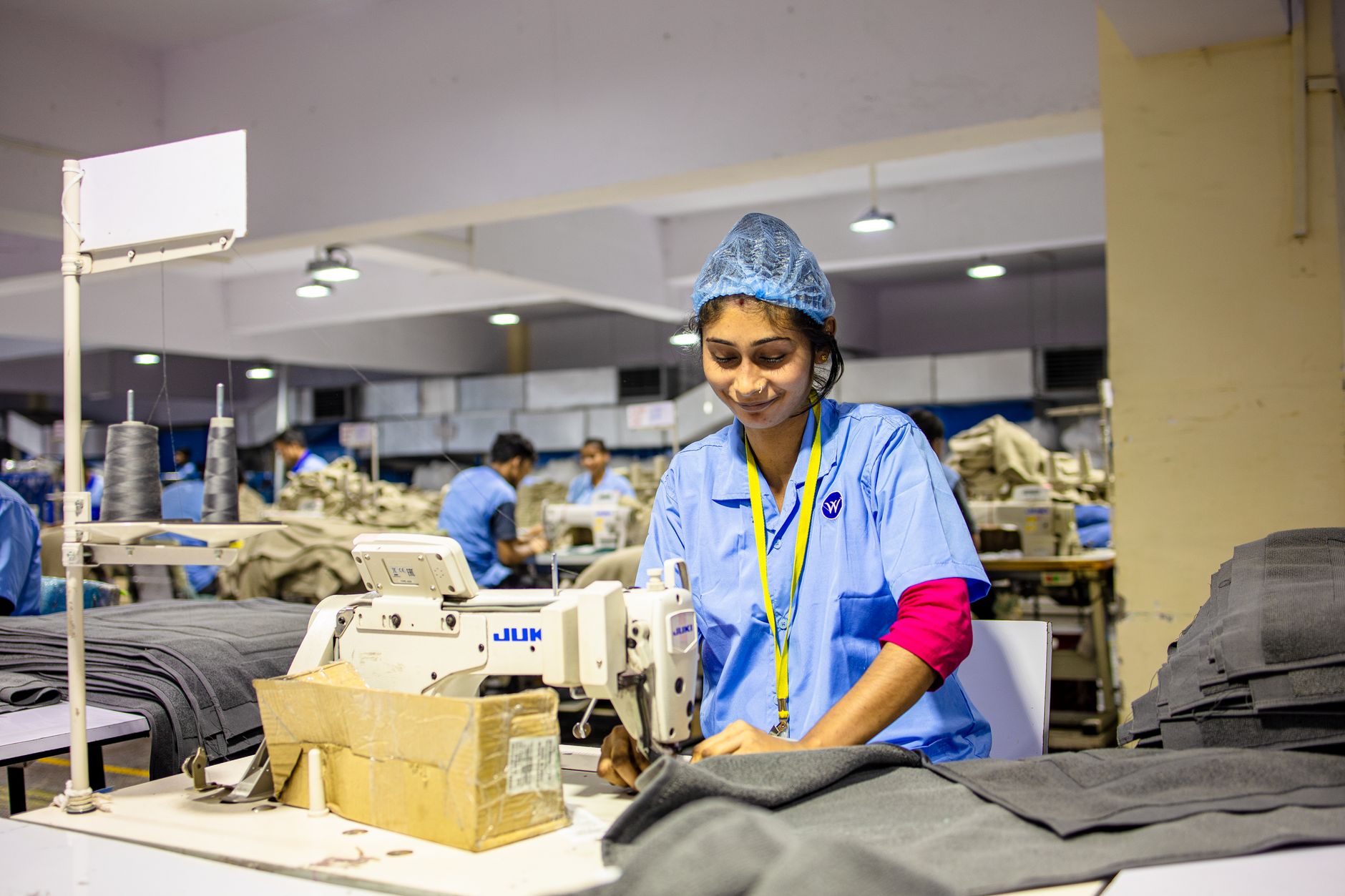Apparel production floor where cut bundles move from the table toward sewing stations.