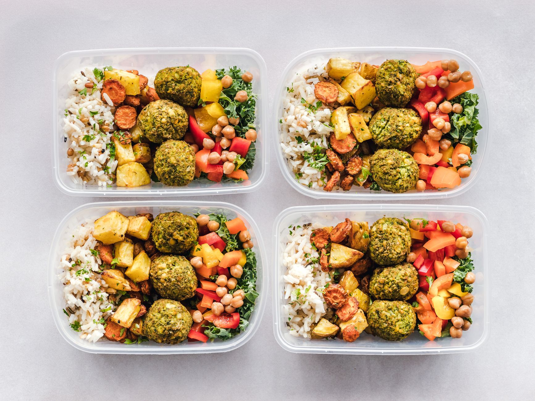 Prepared meal trays in plastic containers, the kind cobots must place flat without crushing portions.