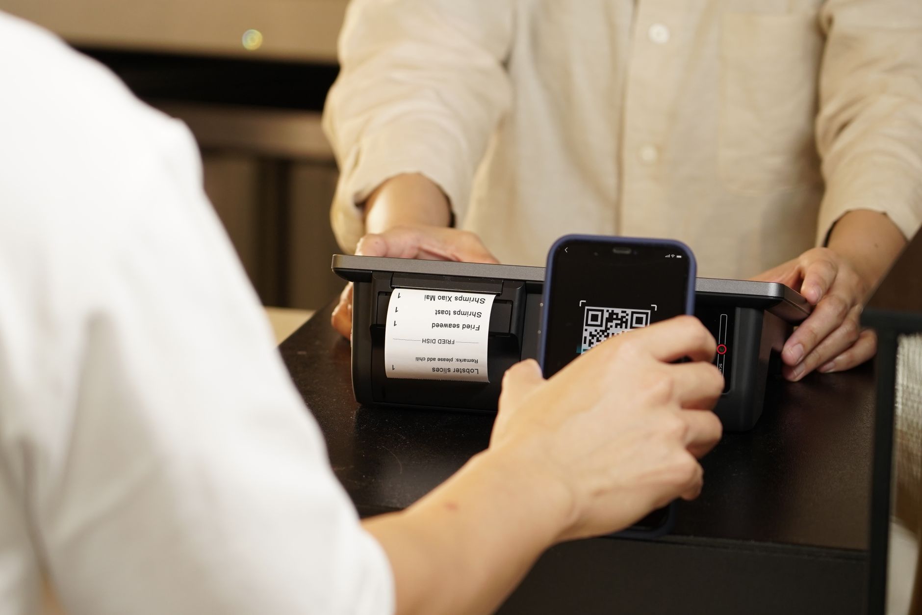 A technician scans a labeled tray of optical parts to load the right recipe for a mixed batch.