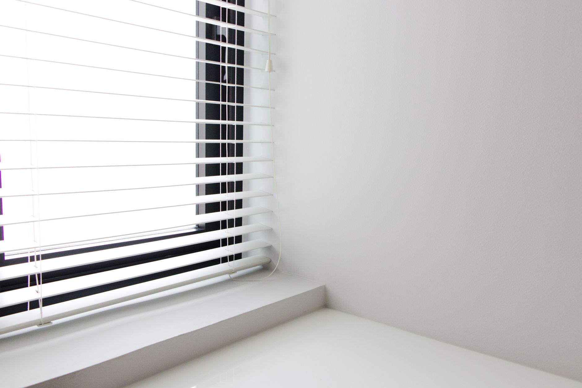 Installed window blinds in a room, showing the long finished units packing lines must protect.